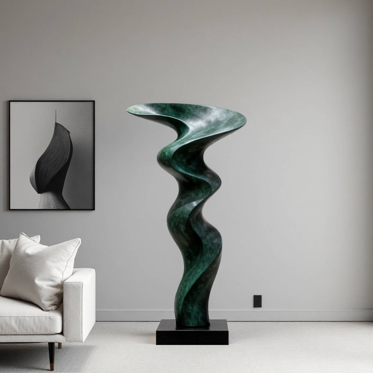 Green bronze abstract sculpture in a modern living room with a gray sofa and abstract art.