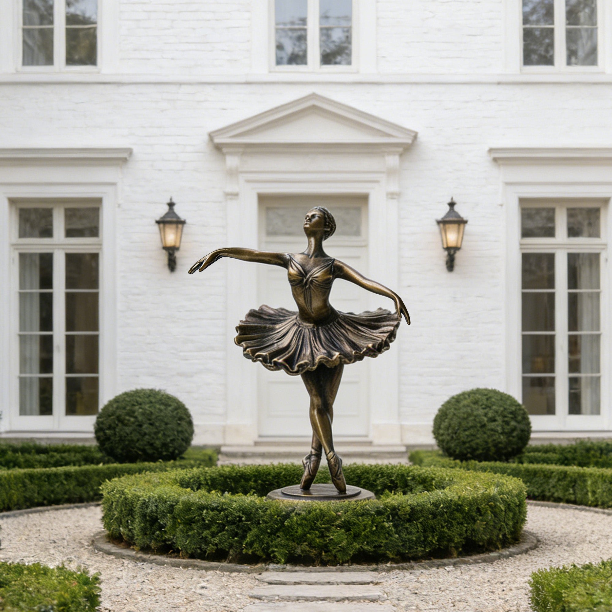 Bronze statue of a ballerina in front of a white building