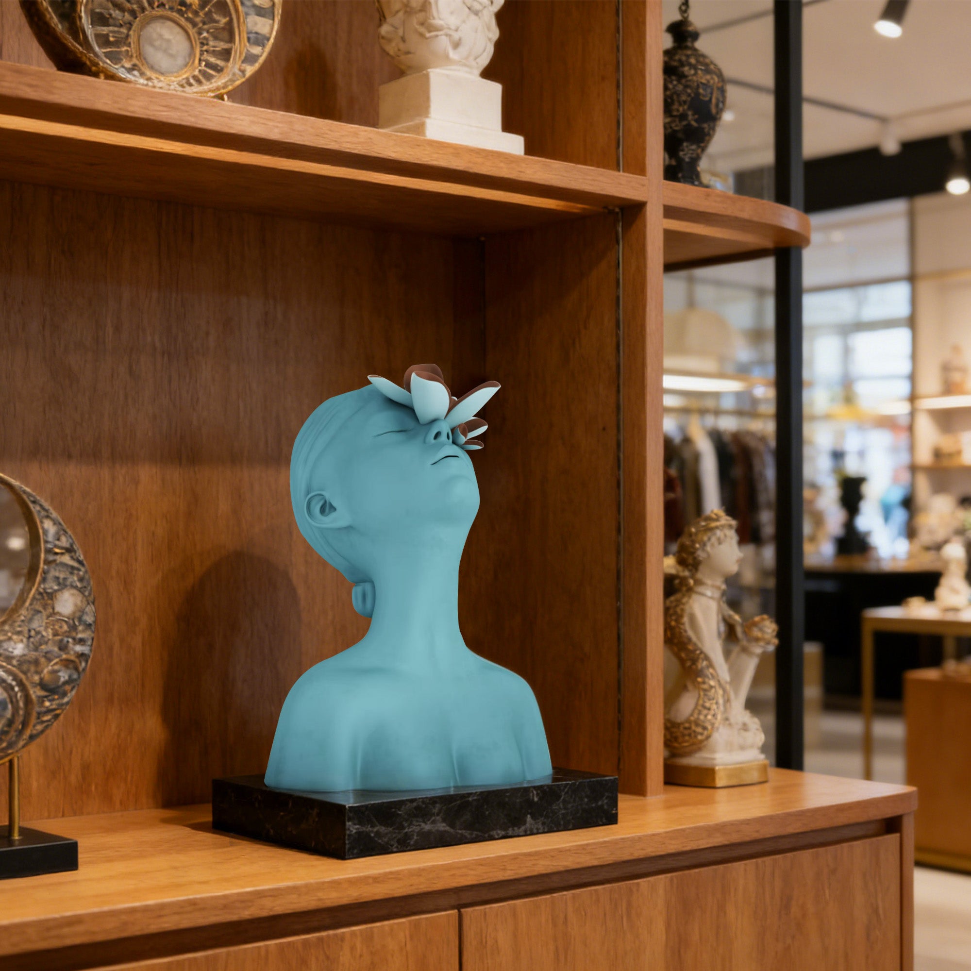 Blue decorative bust on a wooden shelf with other ornaments