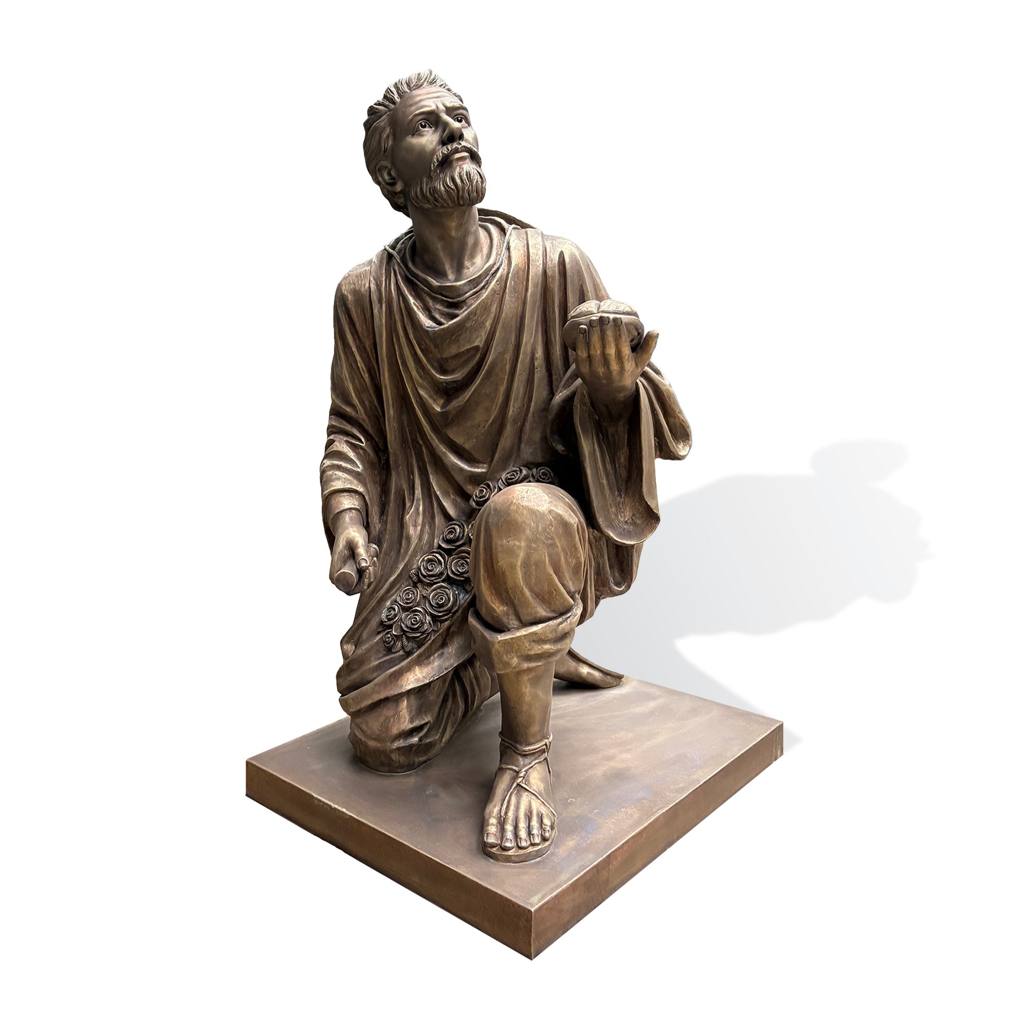 Front view of a bronze Saint Juan Diego statue holding bread in one hand, featuring detailed robes, expressive craftsmanship, and an upward gaze symbolizing faith and devotion.