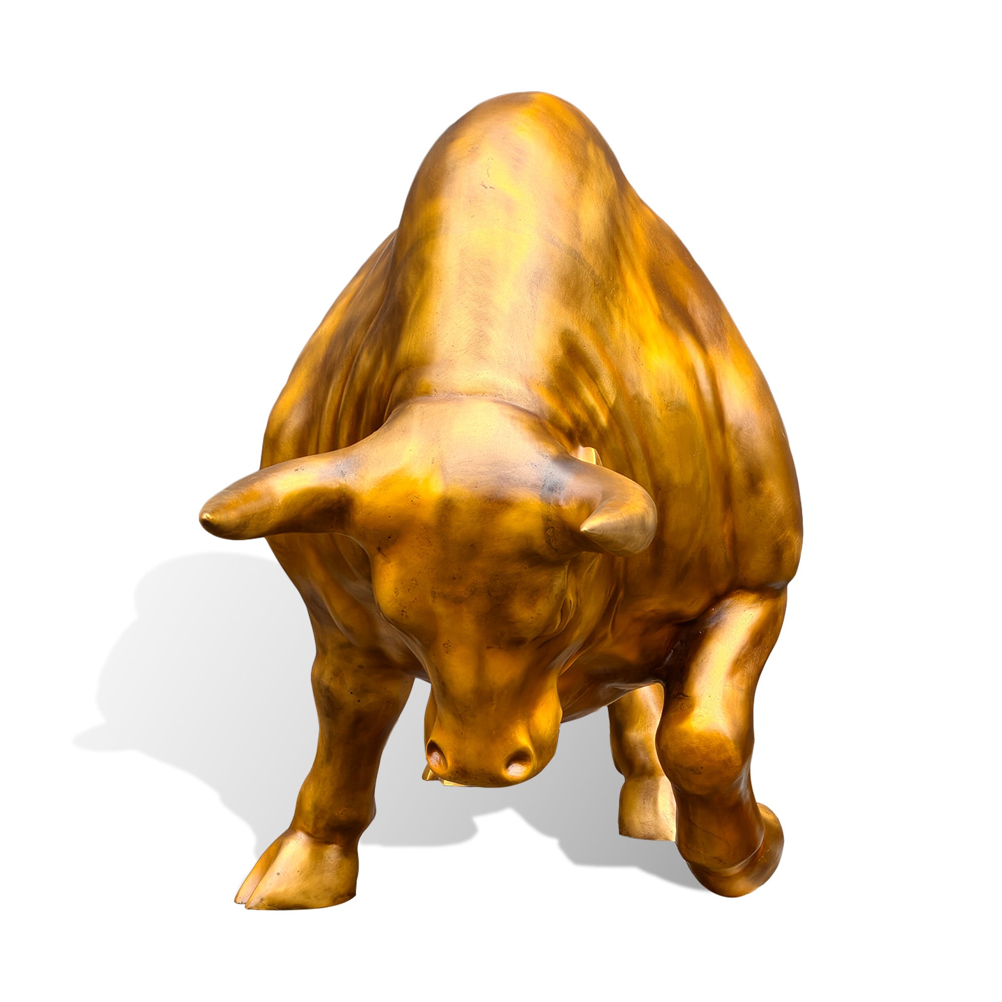 Front view of a golden bronze charging bull sculpture with a lowered head, symmetrical horns, muscular shoulders, grounded front hoof, and lifted leg