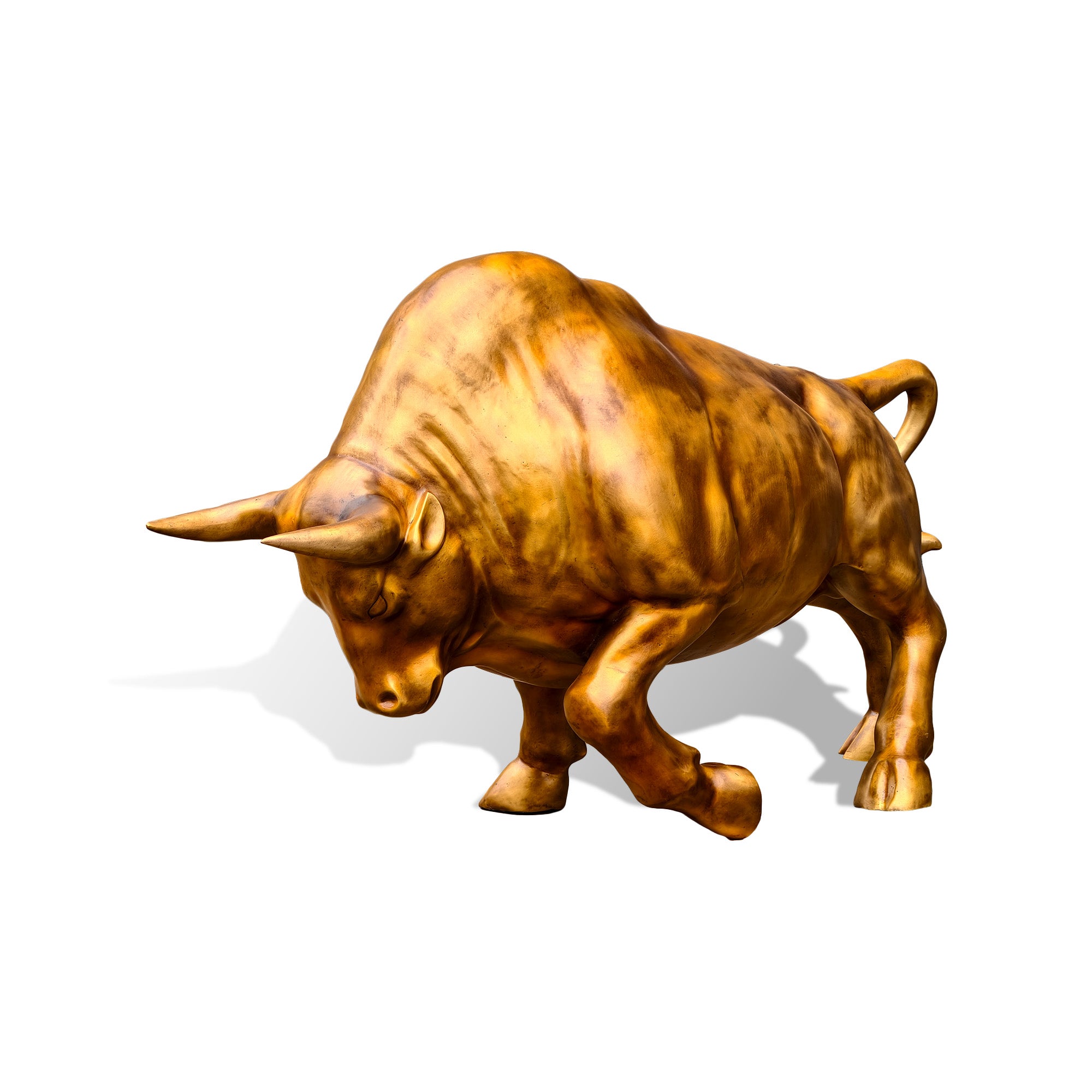 a golden bronze charging bull sculpture with a lowered head, forward-pointing horns, raised front leg, muscular body, and curled tail