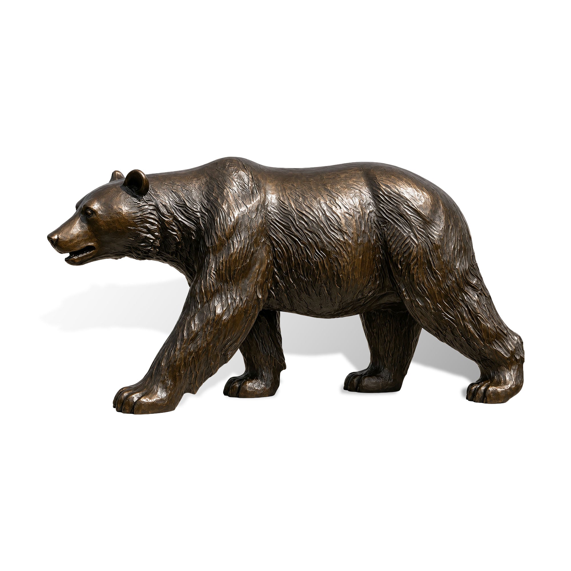 Side view of a bronze walking bear statue on a white background, highlighting lifelike fur details, strong body shape, extended front paw, open mouth, and realistic wildlife form.