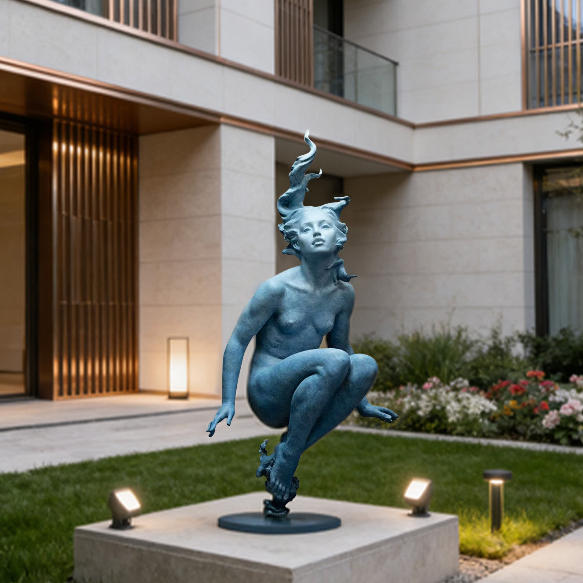 Modern bronze woman sculpture with blue patina finish displayed in a residential courtyard garden, featuring floating seated pose, flowing hair, and outdoor art lighting