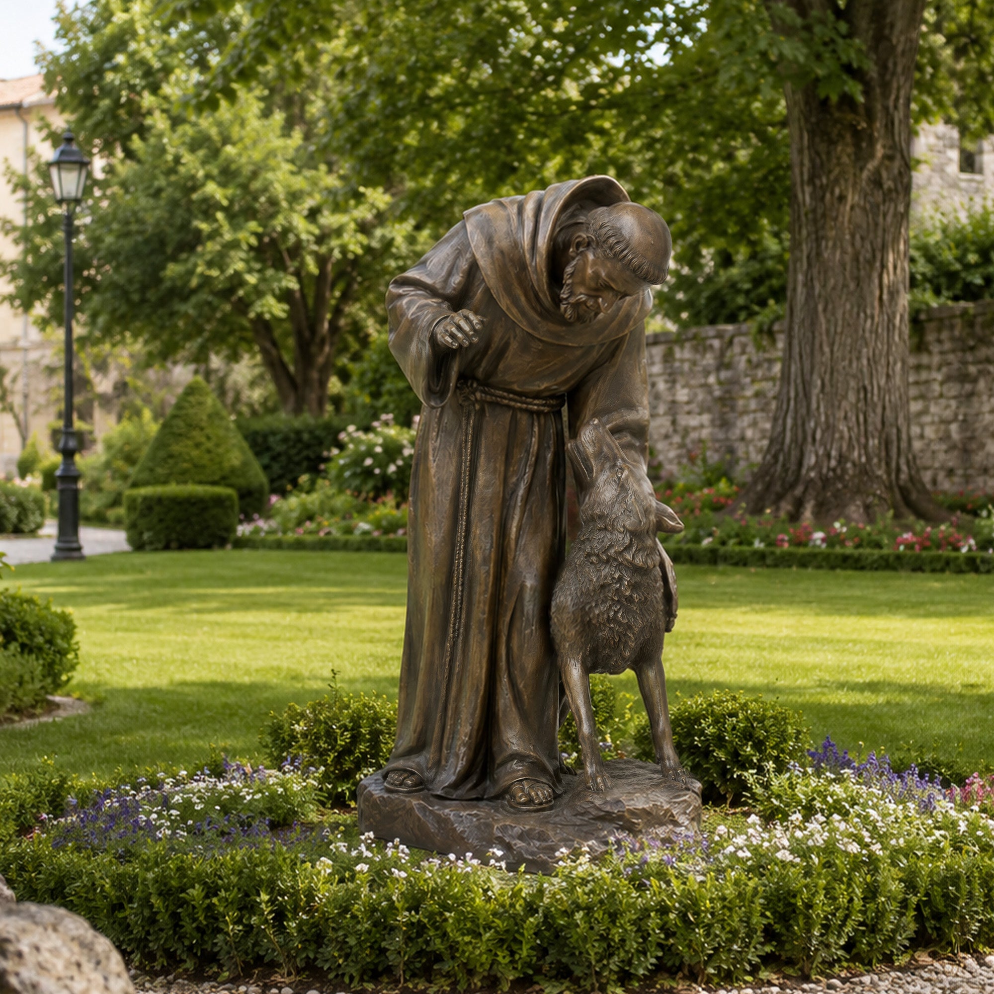 Bronze Saint Francis statue displayed in a landscaped garden with a robed monk figure gently touching a wolf, symbolizing compassion, peace, and Christian devotion.