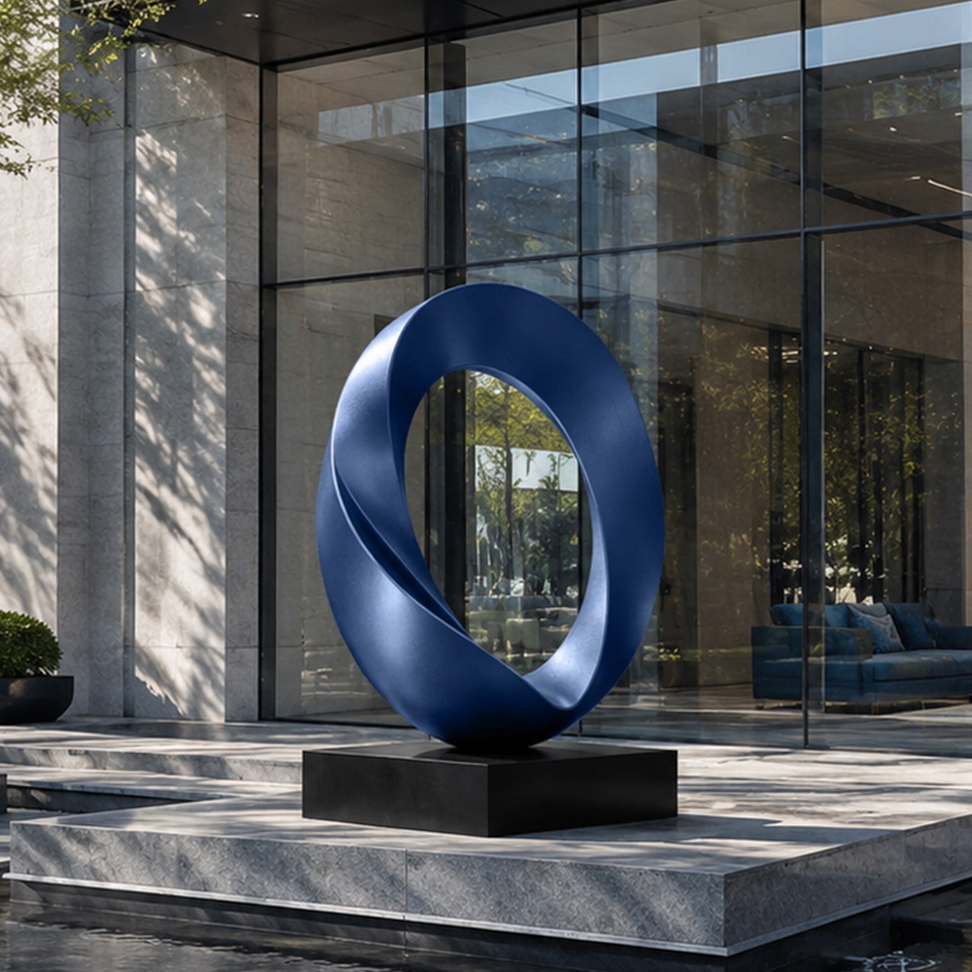 Modern blue abstract ring sculpture displayed in front of a contemporary commercial building, creating a striking focal point for outdoor plazas, office entrances, and landscape architecture.
