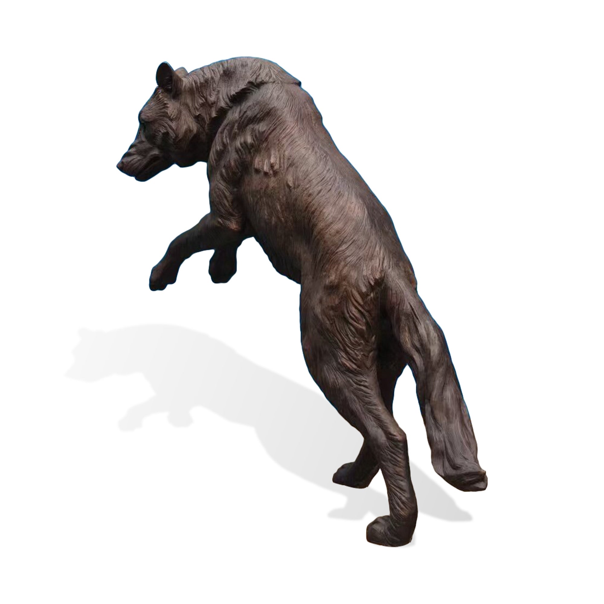 Side back view of a realistic bronze wolf statue showing detailed carved fur, muscular body structure, raised legs, and artistic wildlife sculpture craftsmanship.