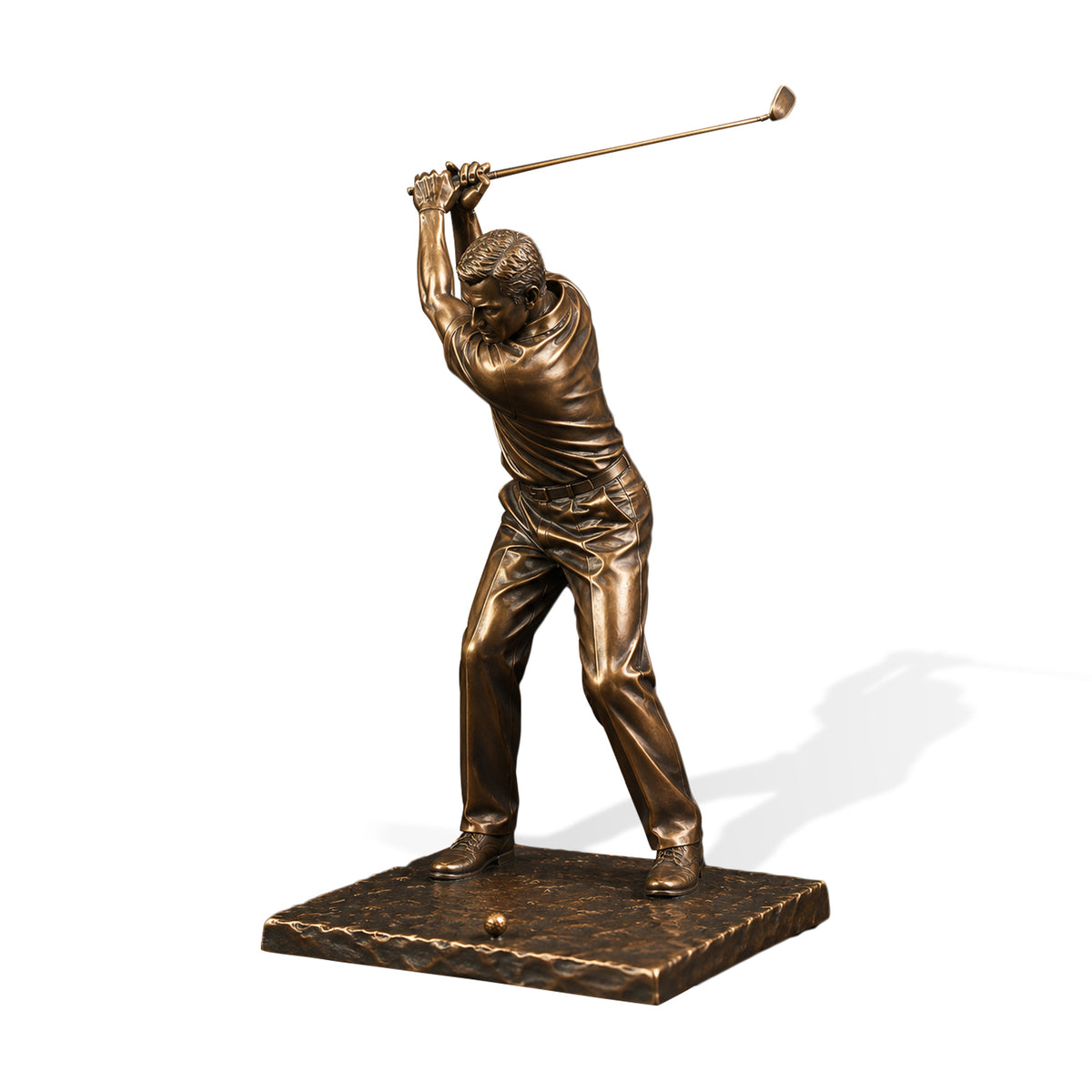 Bronze golfer statue shown on a white background, featuring a male golfer captured at the top of his backswing with both hands gripping a raised golf club, realistic clothing folds, golf shoes, ball, textured rectangular base, and warm antique bronze finish.