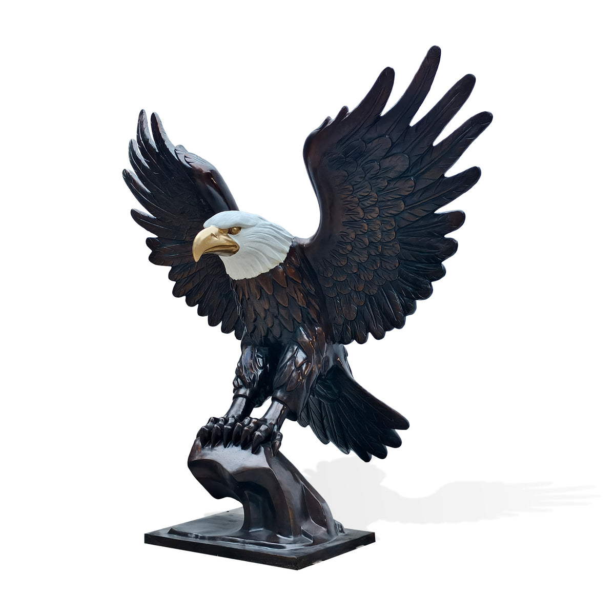 Bronze bald eagle sculpture with spread wings perched on a bronze pedestsl , angled front view