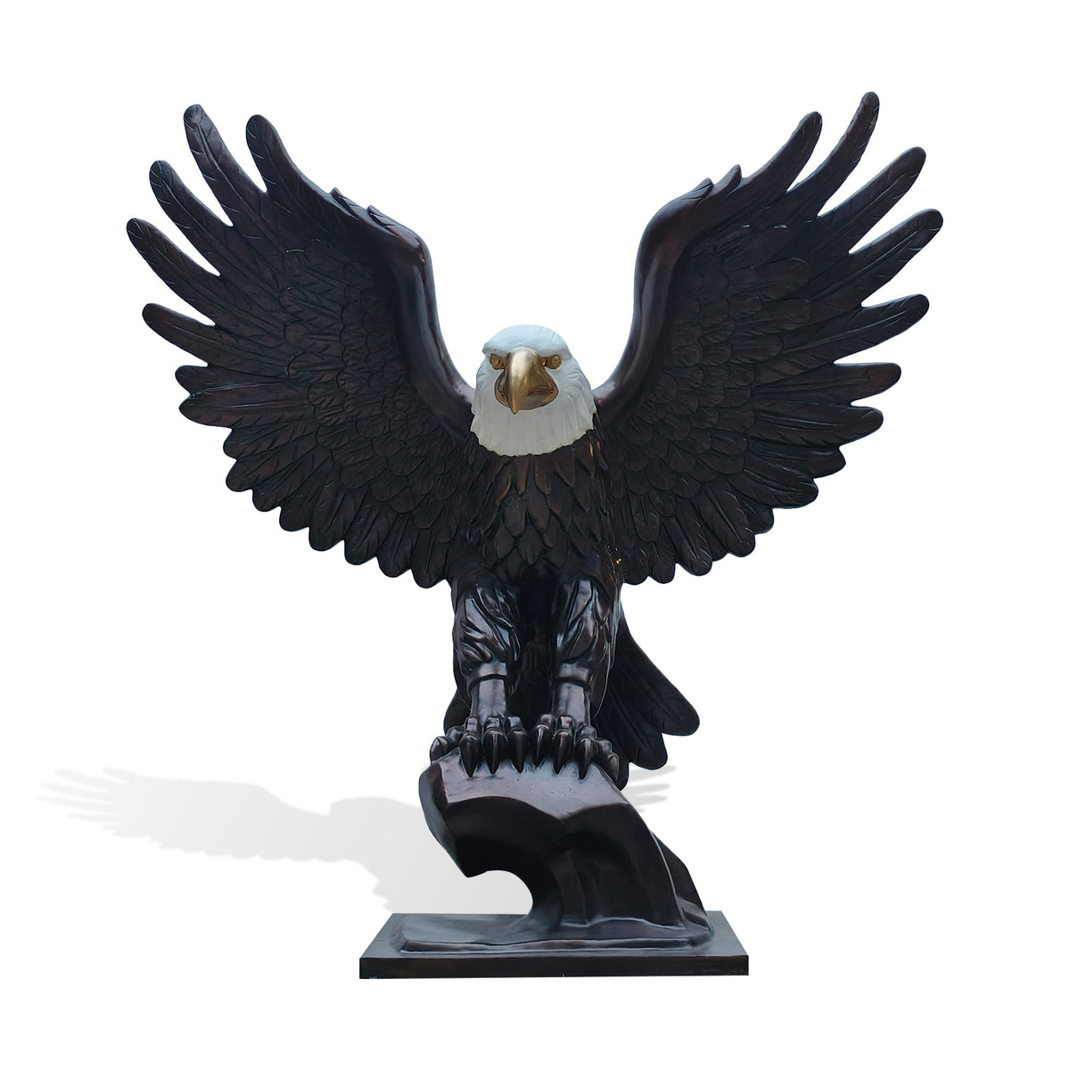 Bronze bald eagle statue with wings fully spread and talons perched on a pedestal, front view