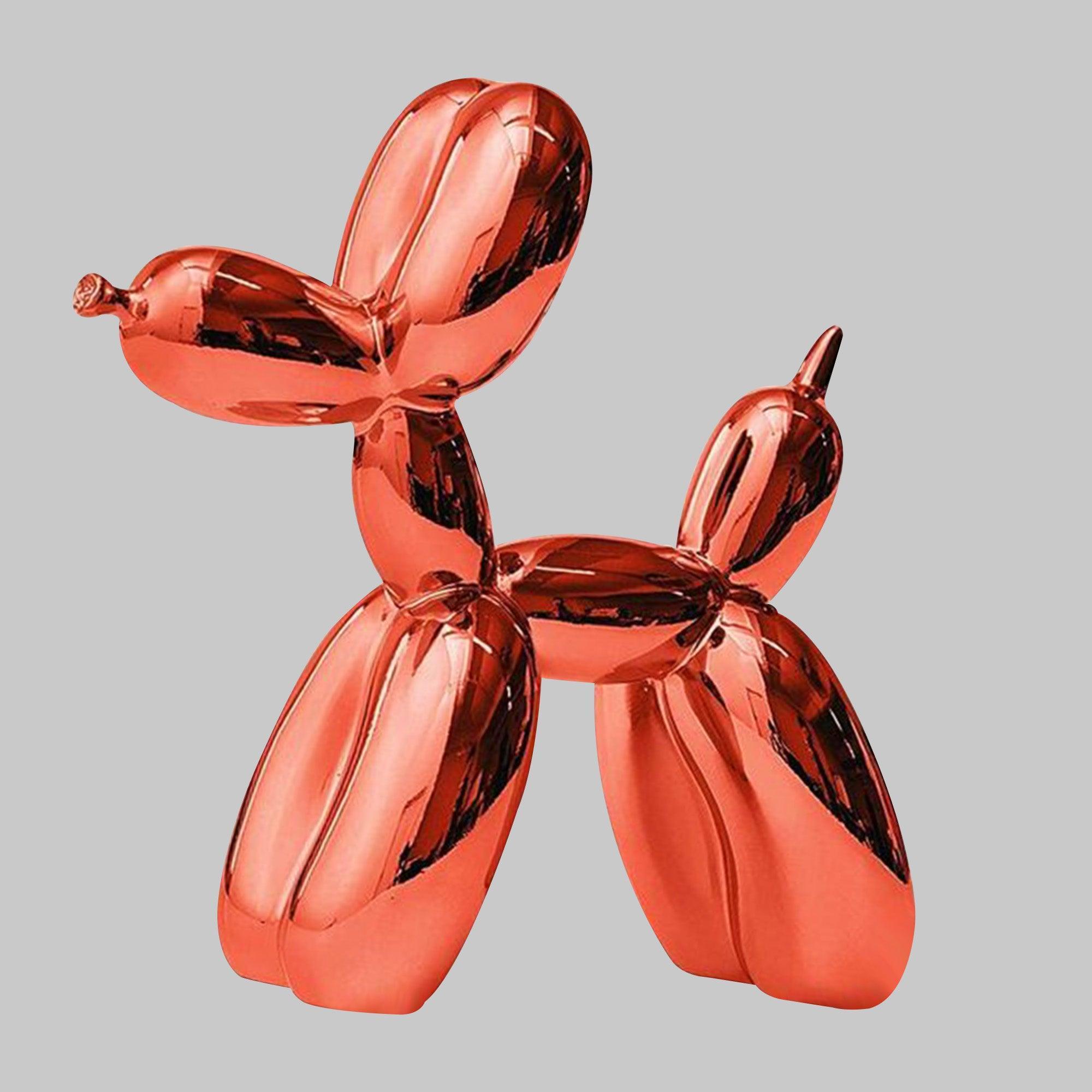 orange balloon dog fiberglass sculpture displaying on the bookshelf