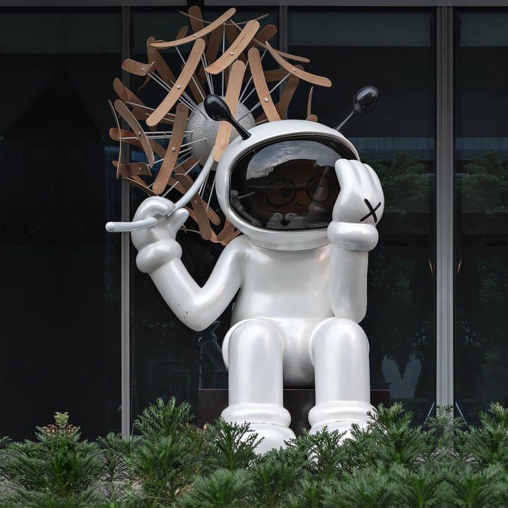 fiberglass white sitting astronaut statue with a dandelion flower on hand