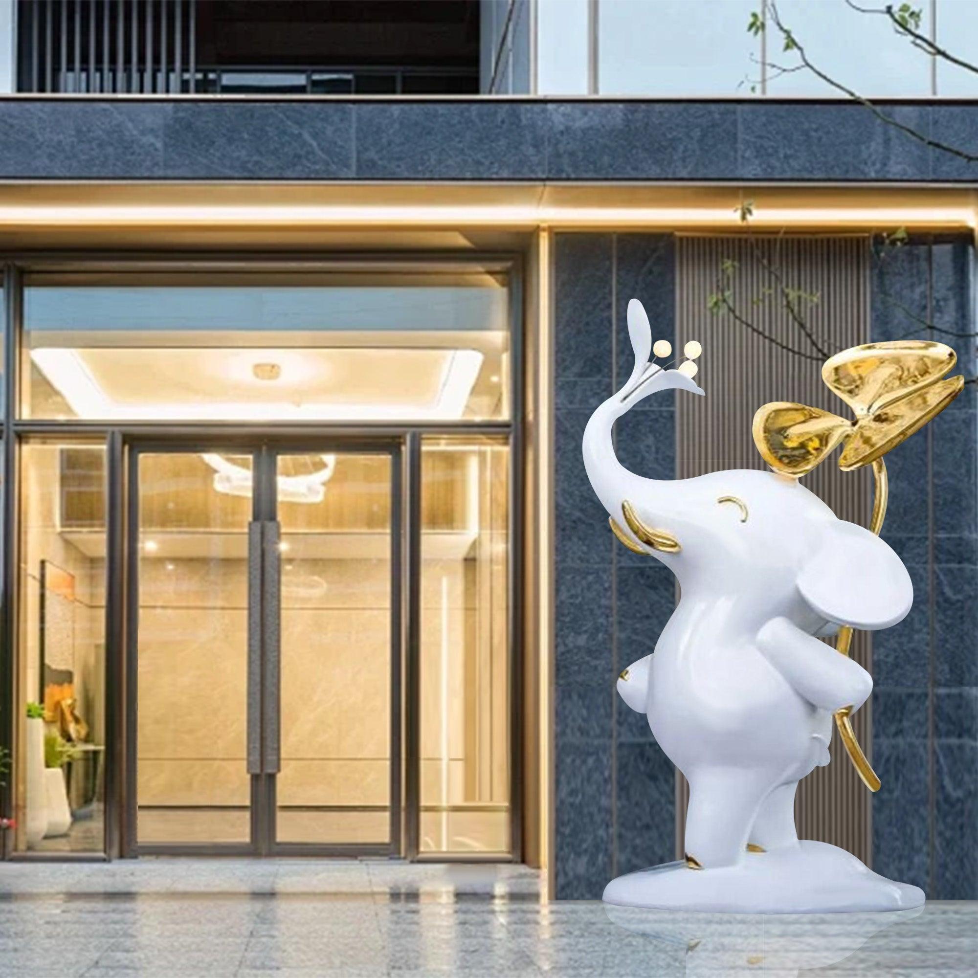 white carton fiberglass standing elephant sculpture in front hotel entrance