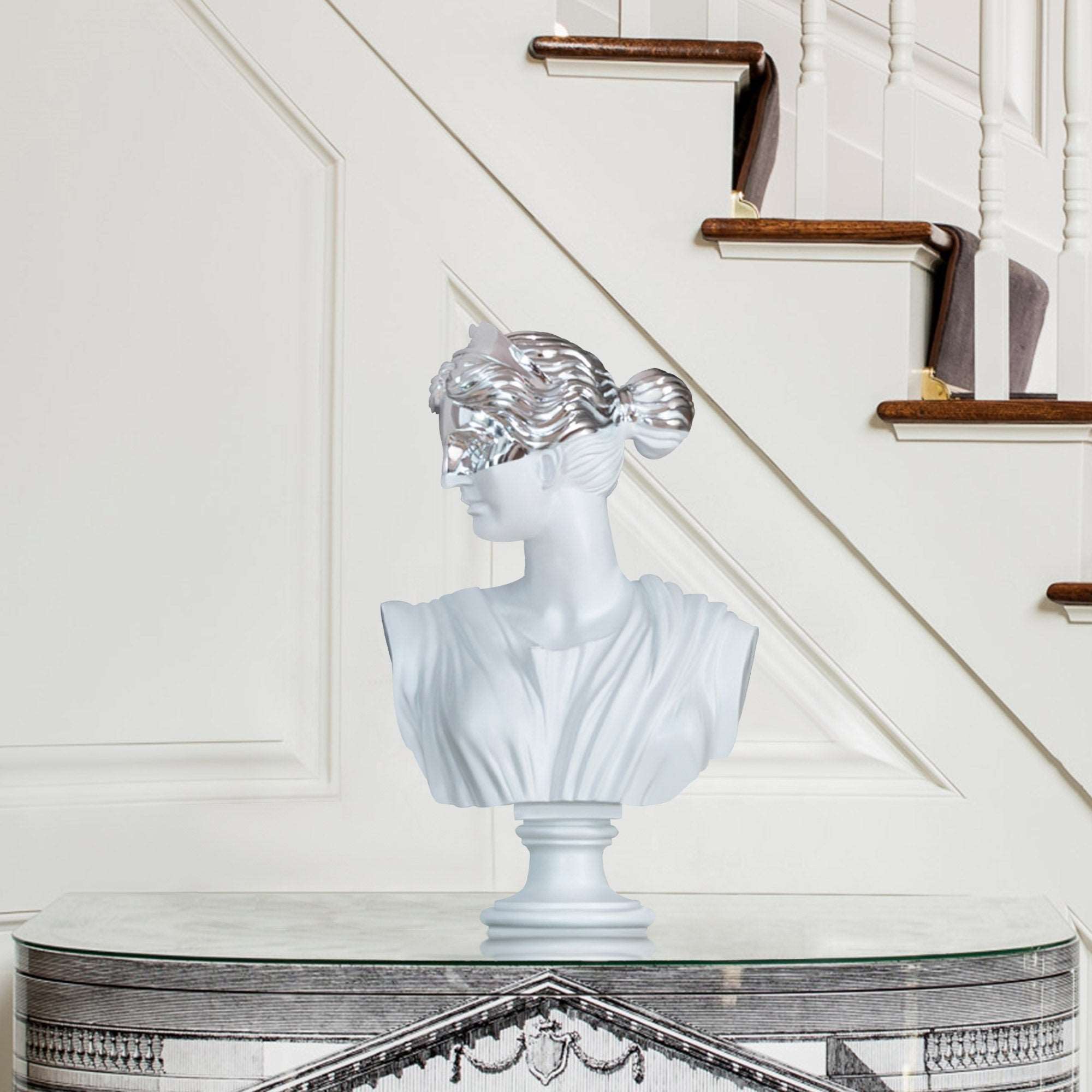 Greek goddess bust sculpture with a chrome mask setting on a lobby desk