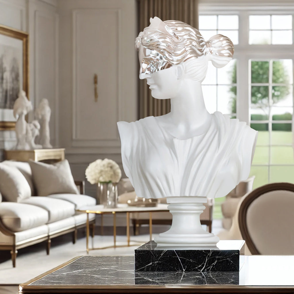 Greek goddess bust sculpture with a chrome mask setting on a lobby desk