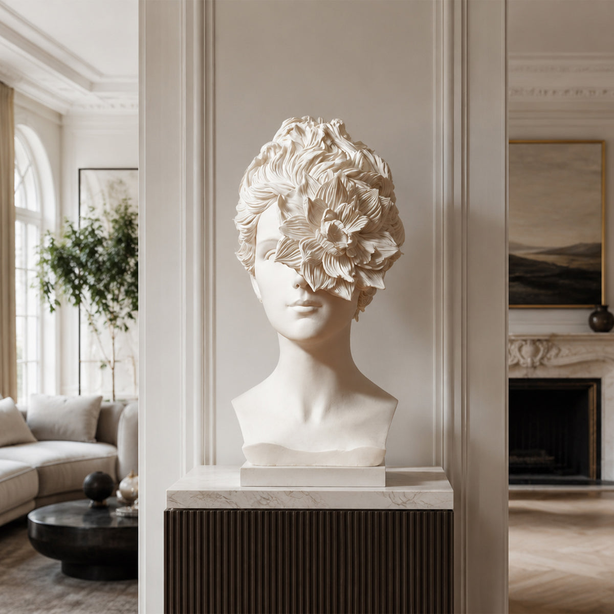 Ivory fiberglass female bust with an oversized layered flower covering one eye and sweeping textured hair, displayed on a marble-topped console in a paneled living room. A pale sofa, indoor tree and fireplace surround the sculpture.