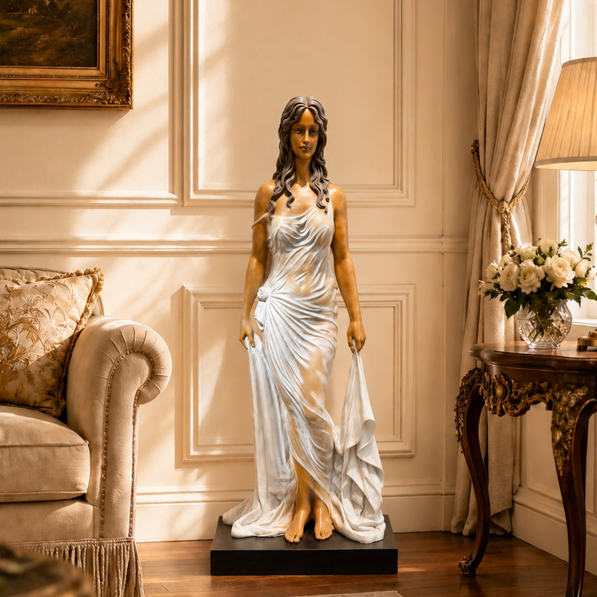 Fiberglass woman statue in a shimmering ivory and champagne gown, displayed on a black base in a traditionally styled living room. Dark flowing hair and warm skin tones contrast with the dress, surrounded by a cream sofa, paneled walls, draped curtains and an ornate side table.