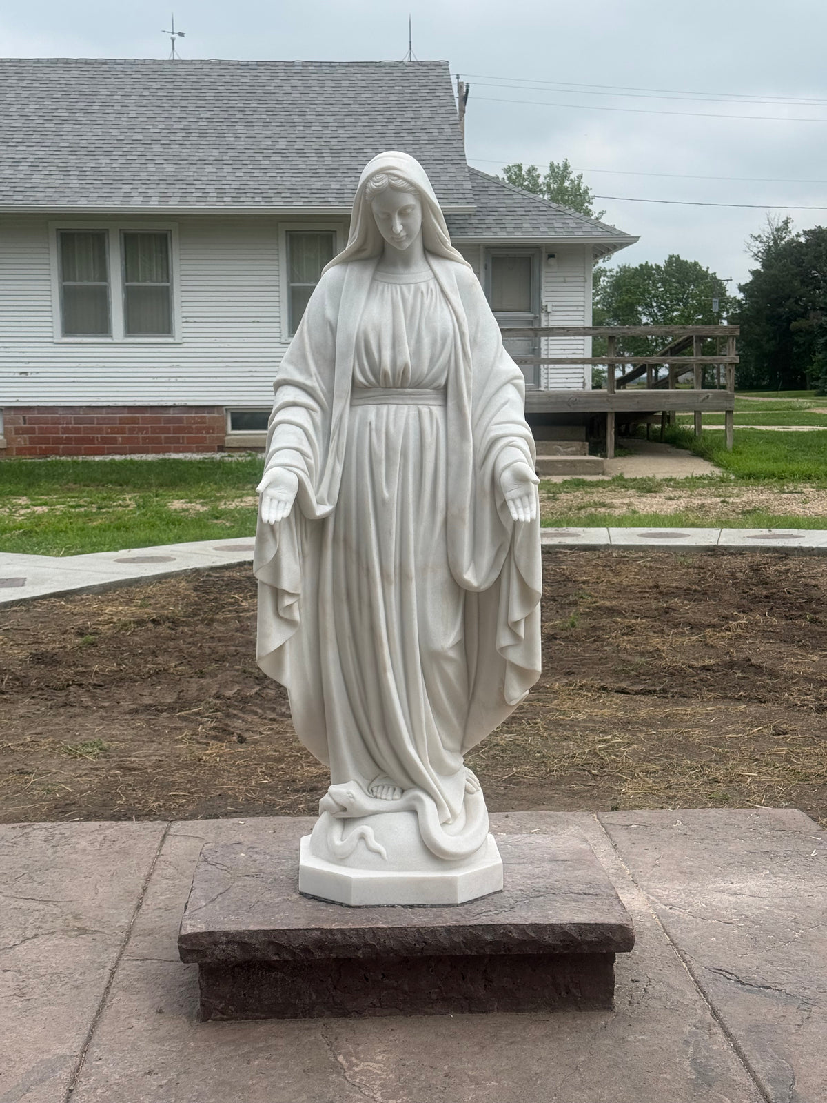 Installed marble Virgin Mary statue in a real-life setting