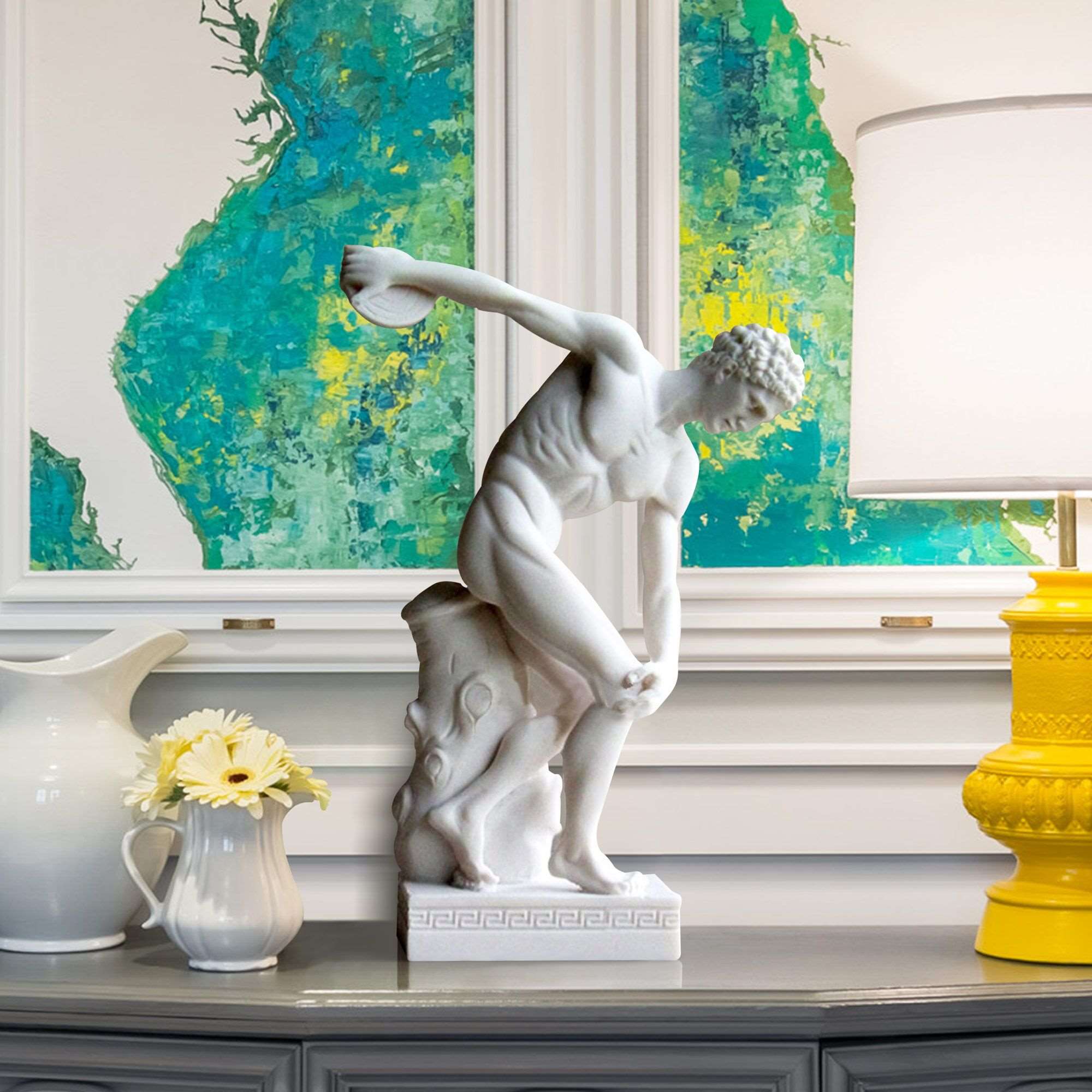 Marble statue of the Discobolus of Myron, depicting an ancient Greek athlete in mid-disc throw, display on indoor desk.