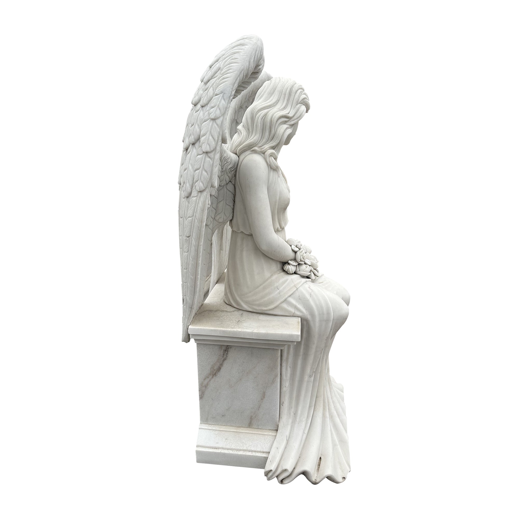 Stone angel statue seated on a bench holding roses