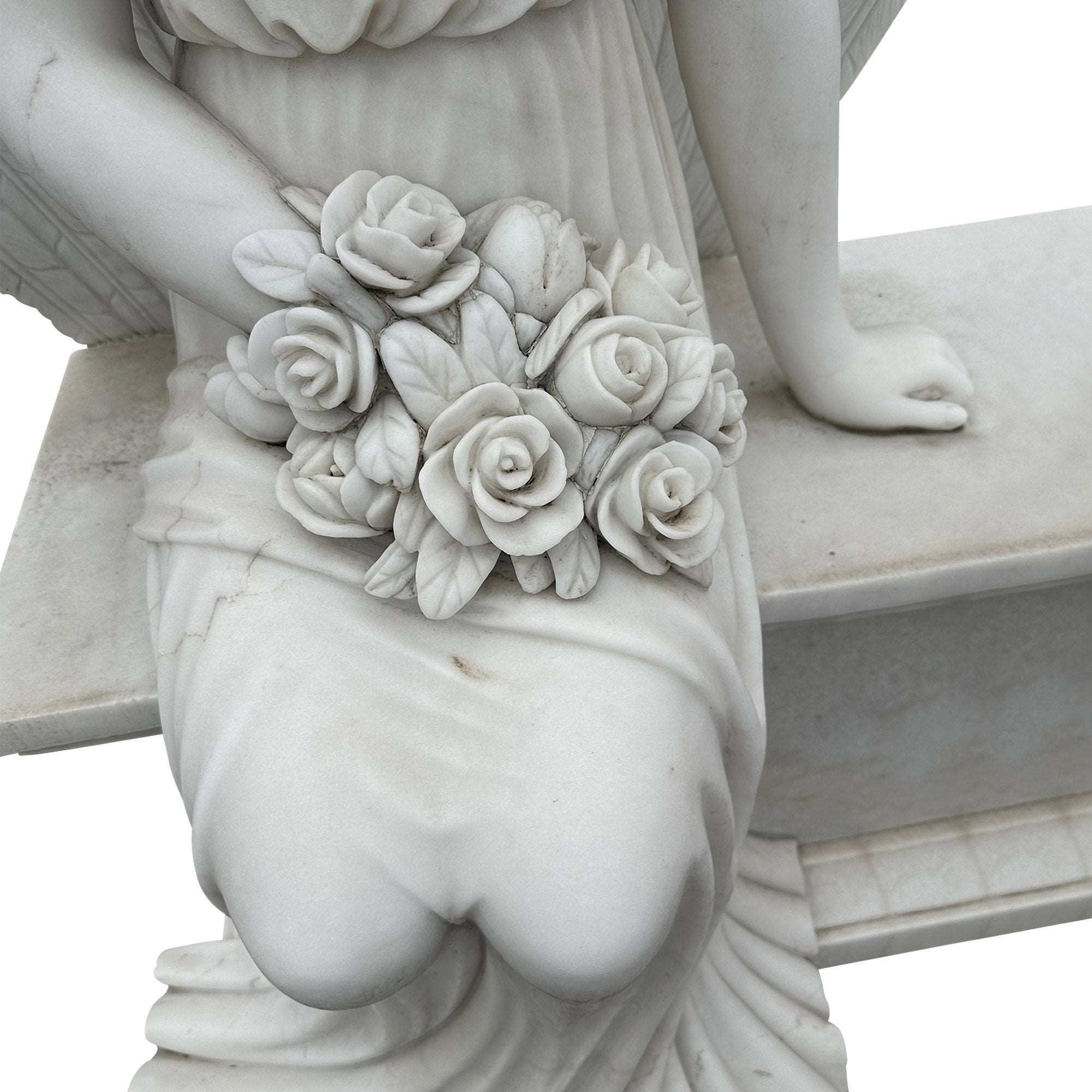 Stone angel statue seated on a bench holding roses