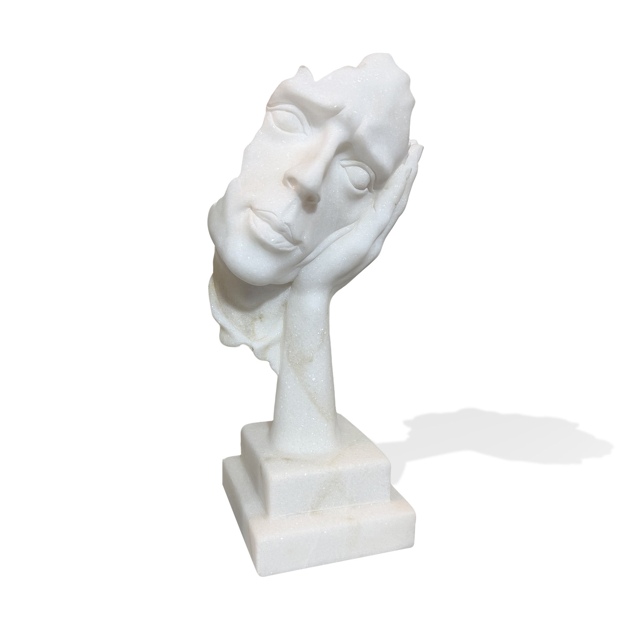 Angled view of a white marble modern face statue resting on a sculpted hand with pedestal base