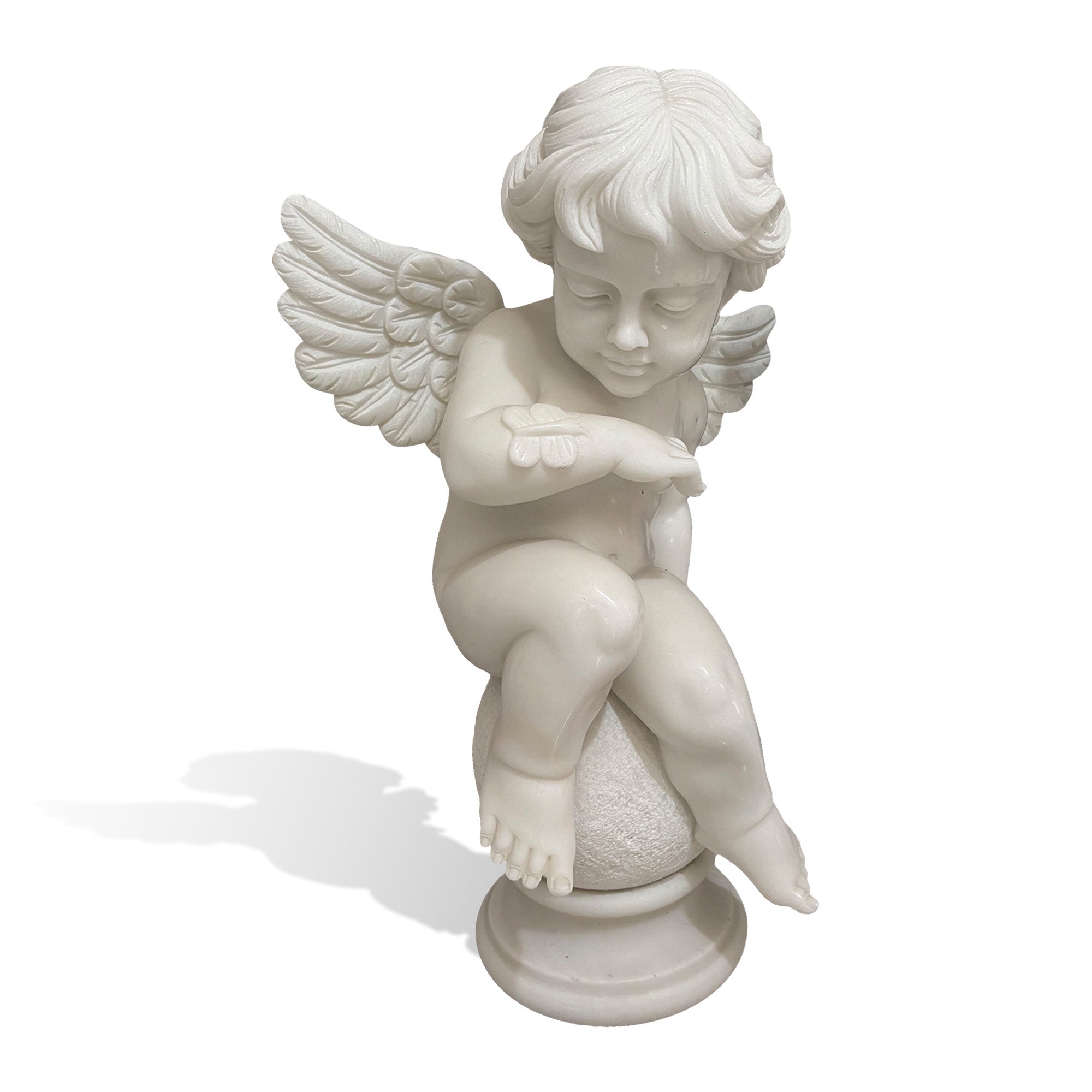 Front view of hand carved white marble cherub angel sculpture looking at a small butterfly resting on his hand with detailed wings and pedestal