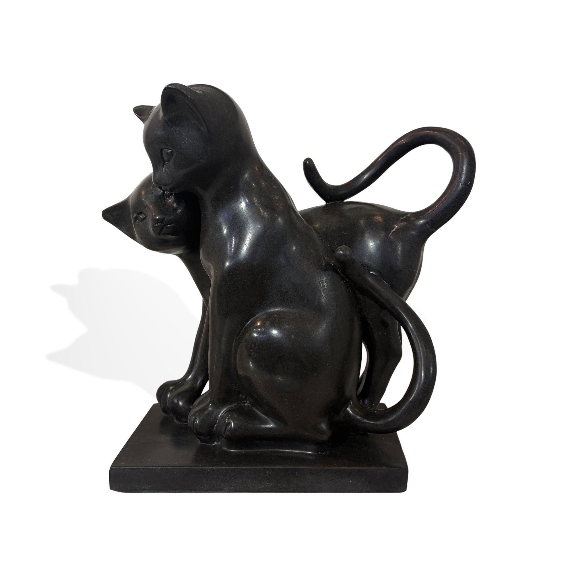 Black stone two cats statue with smooth polished surface, curved tails, and affectionate cuddling pose on a square base