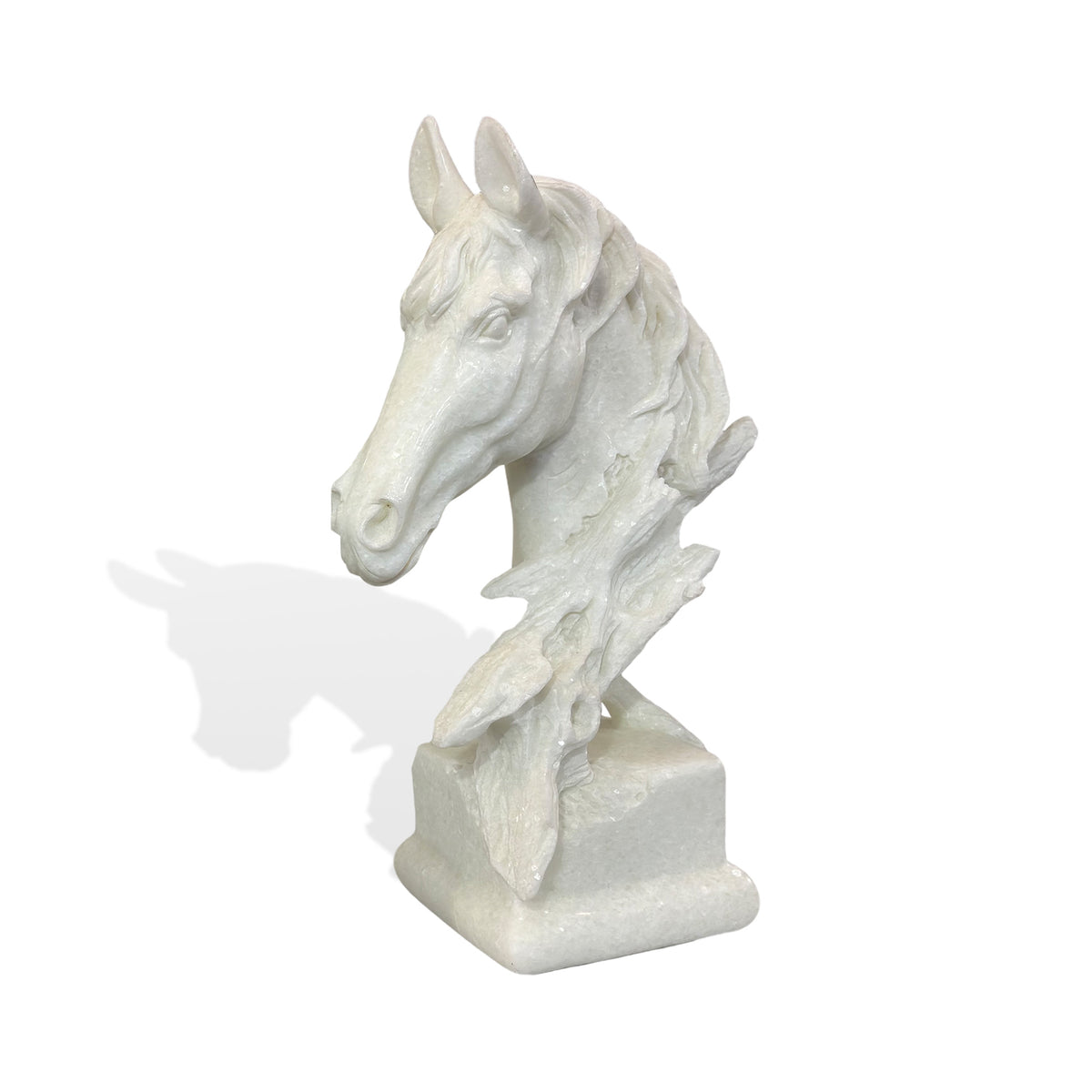 White marble horse head sculpture featuring an elongated muzzle, upright ears, expressive carved eyes, and a flowing layered mane, supported by a sculptural tree branch form and rectangular marble base with natural stone texture and subtle ivory veining.
