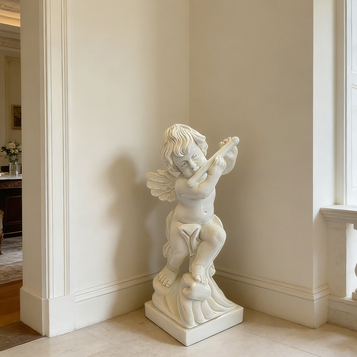 White marble musical cherub sculpture carved from a single stone block, displayed beside a tall window in an elegant classical villa interior.