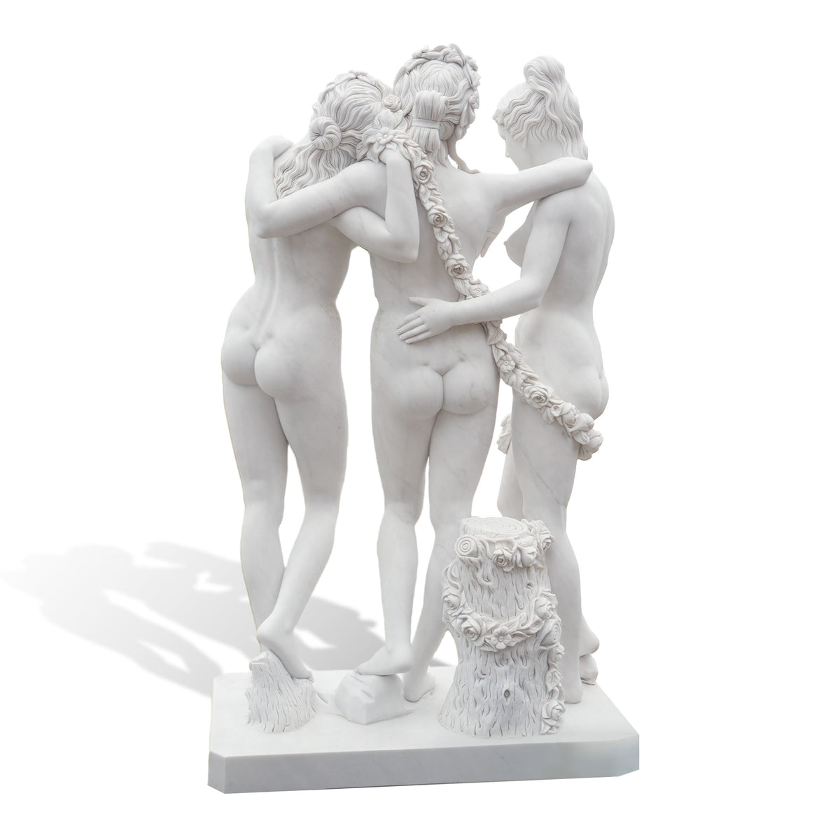 Rear view of The Three Graces marble statue replica, highlighting sculpted backs, braided hairstyles, floral garlands and a rose-decorated tree stump.