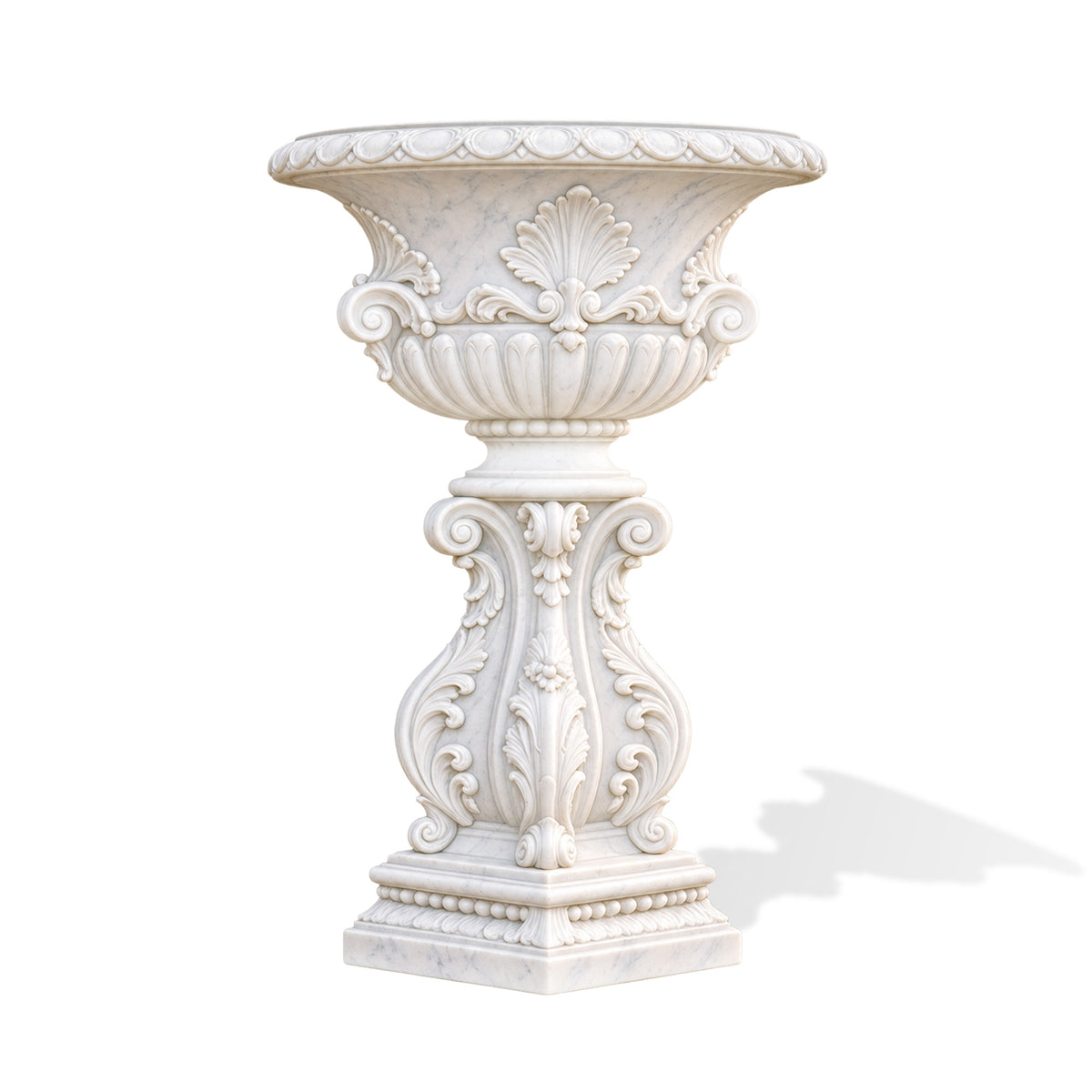 Front view of a white marble urn planter with subtle gray veining, a wide patterned rim, raised shell motifs, curling scrolls and a fluted bowl. A tall pedestal decorated with carved leaves, flowers and bead molding rises from a stepped square base against a white background.