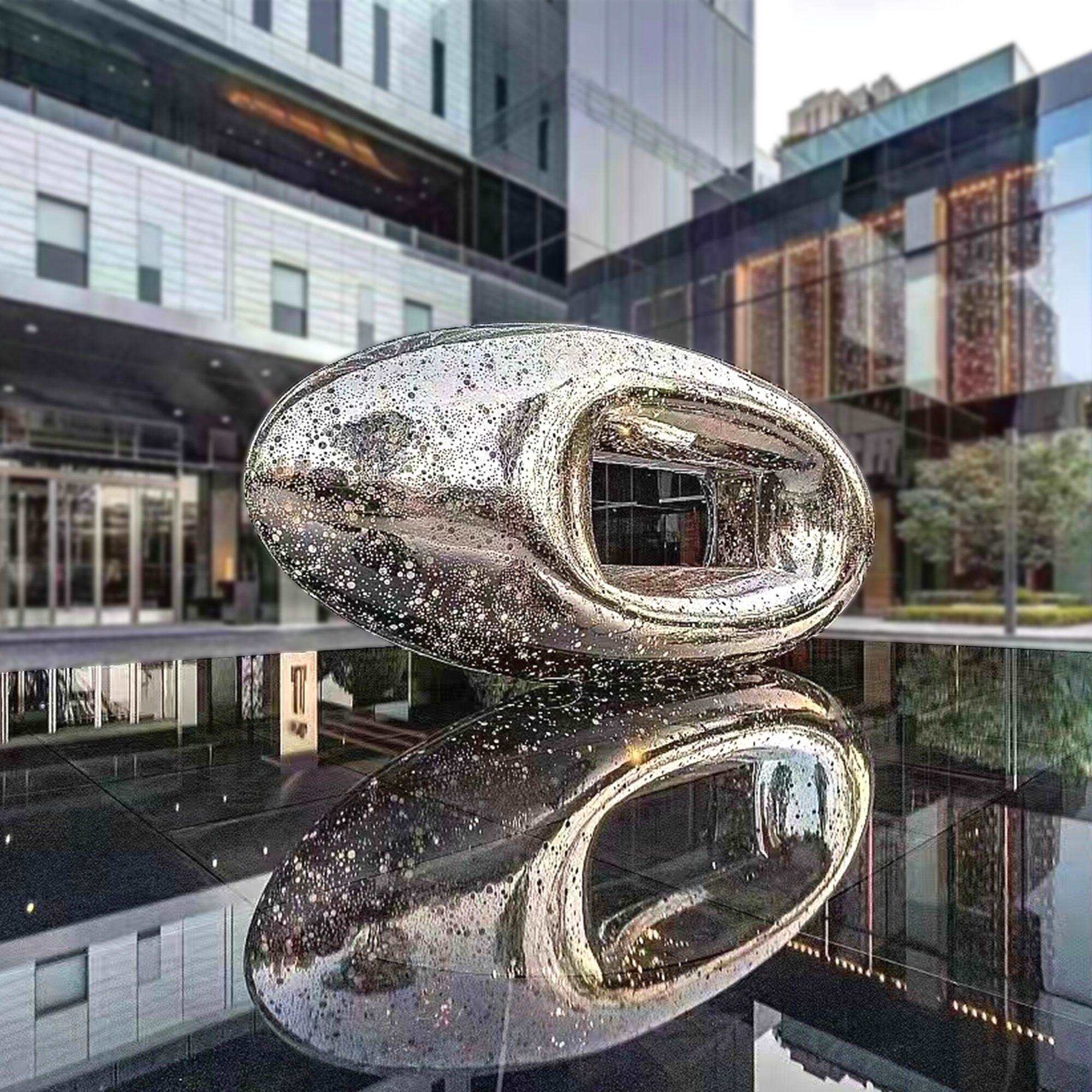 mirrored surface large scale stainless steel water sculpture above pool