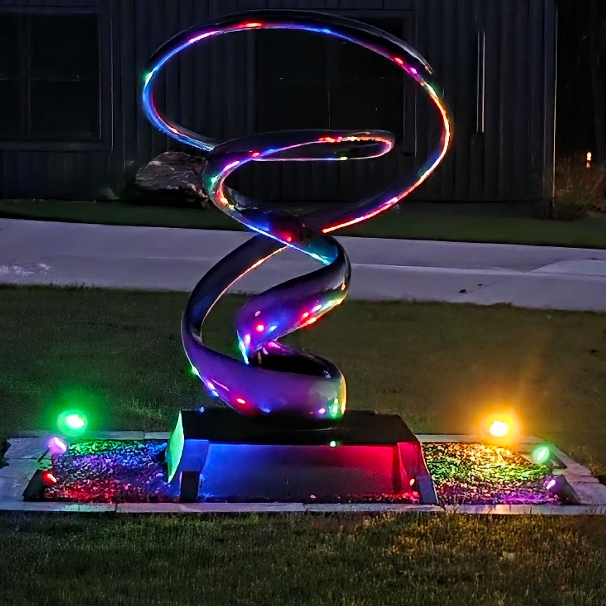 colorful led light abstract outdoor metal sculpture glowing at night at savannah way muskegon michigan