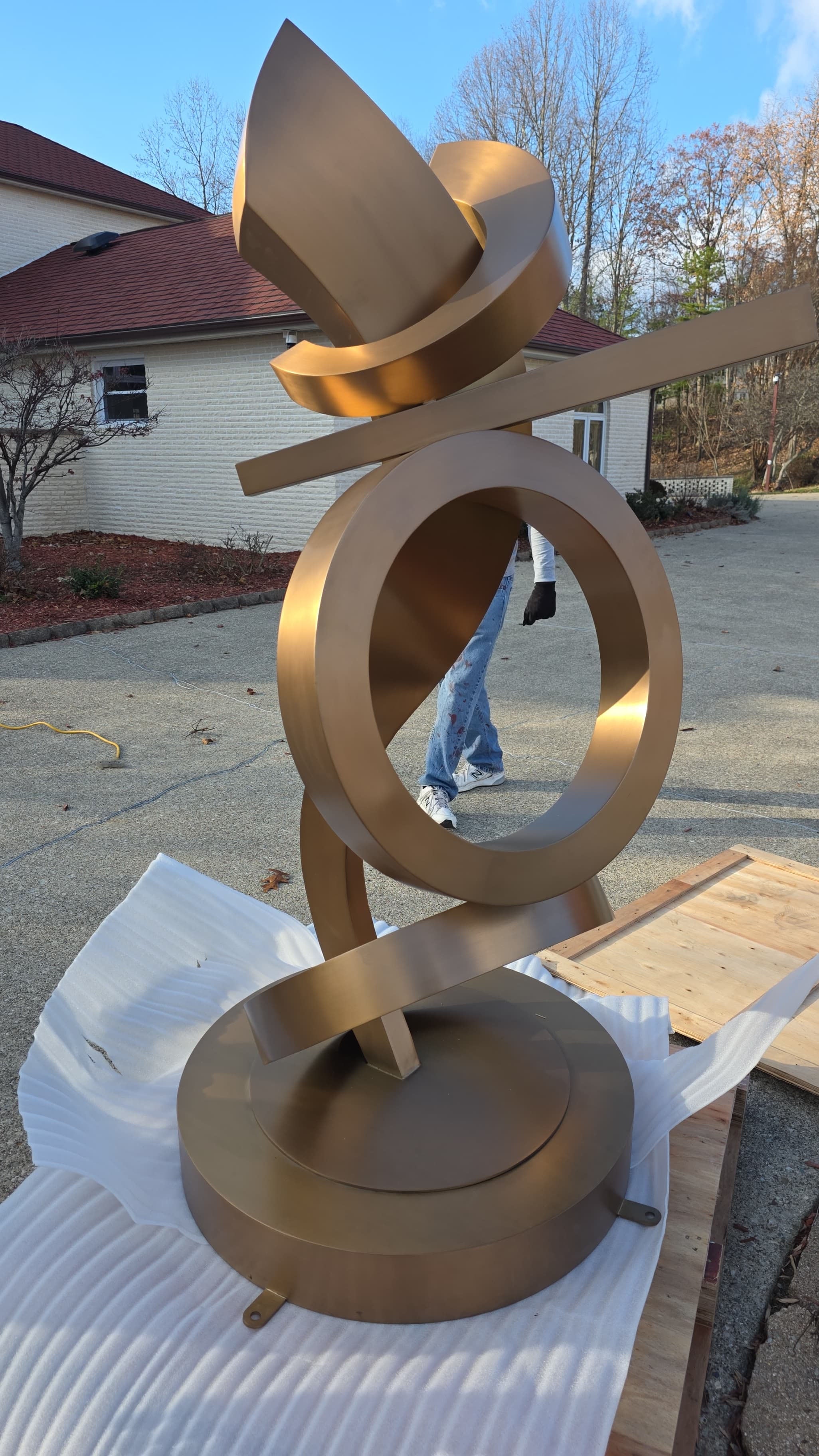 rose gold stainless steel abstract outdoor sculpture, modern design with smooth curves and a reflective rose gold finish, ideal for contemporary outdoor spaces and luxury landscaping.
