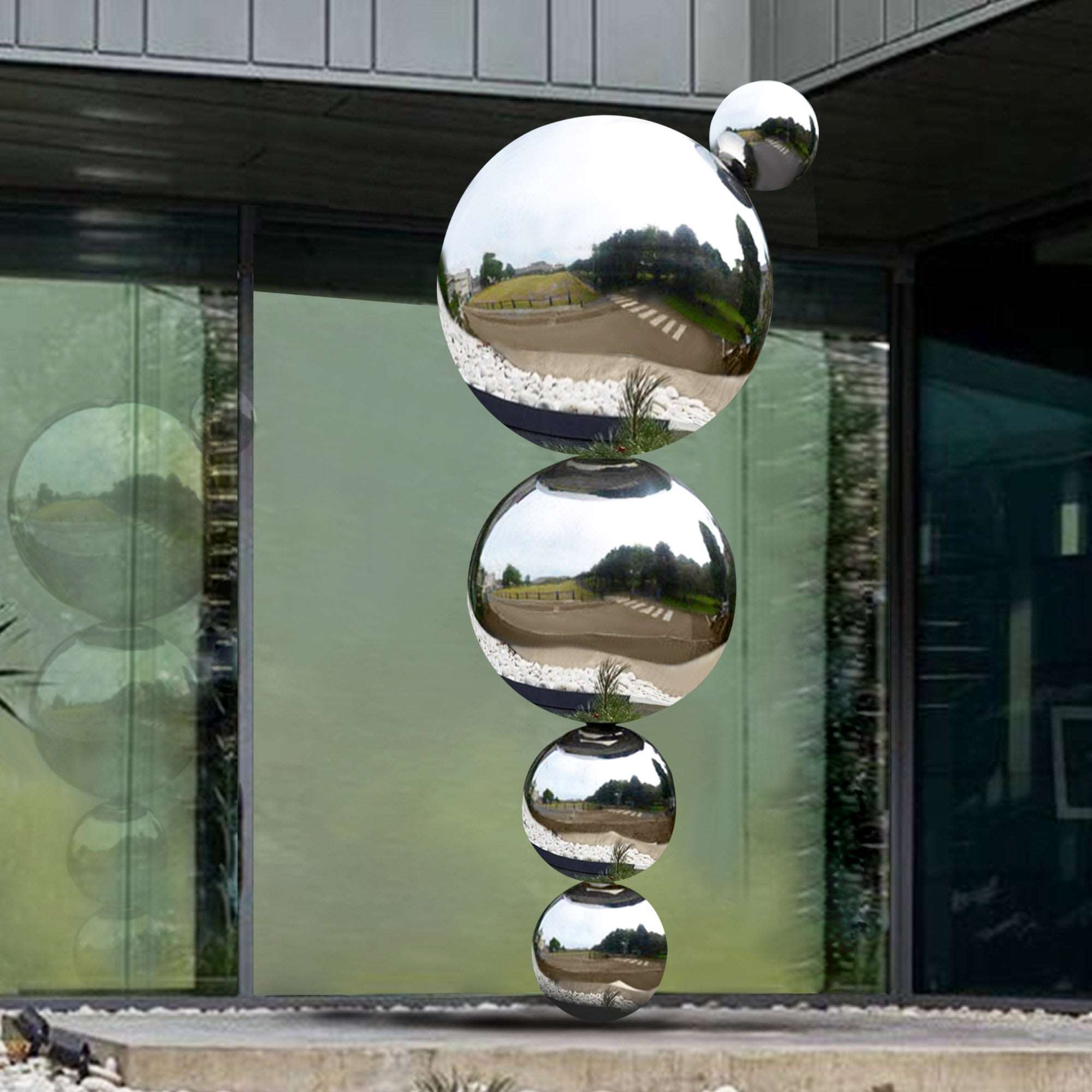 Stacked sphere sculpture made of high-gloss polished stainless steel, reflecting its surroundings.