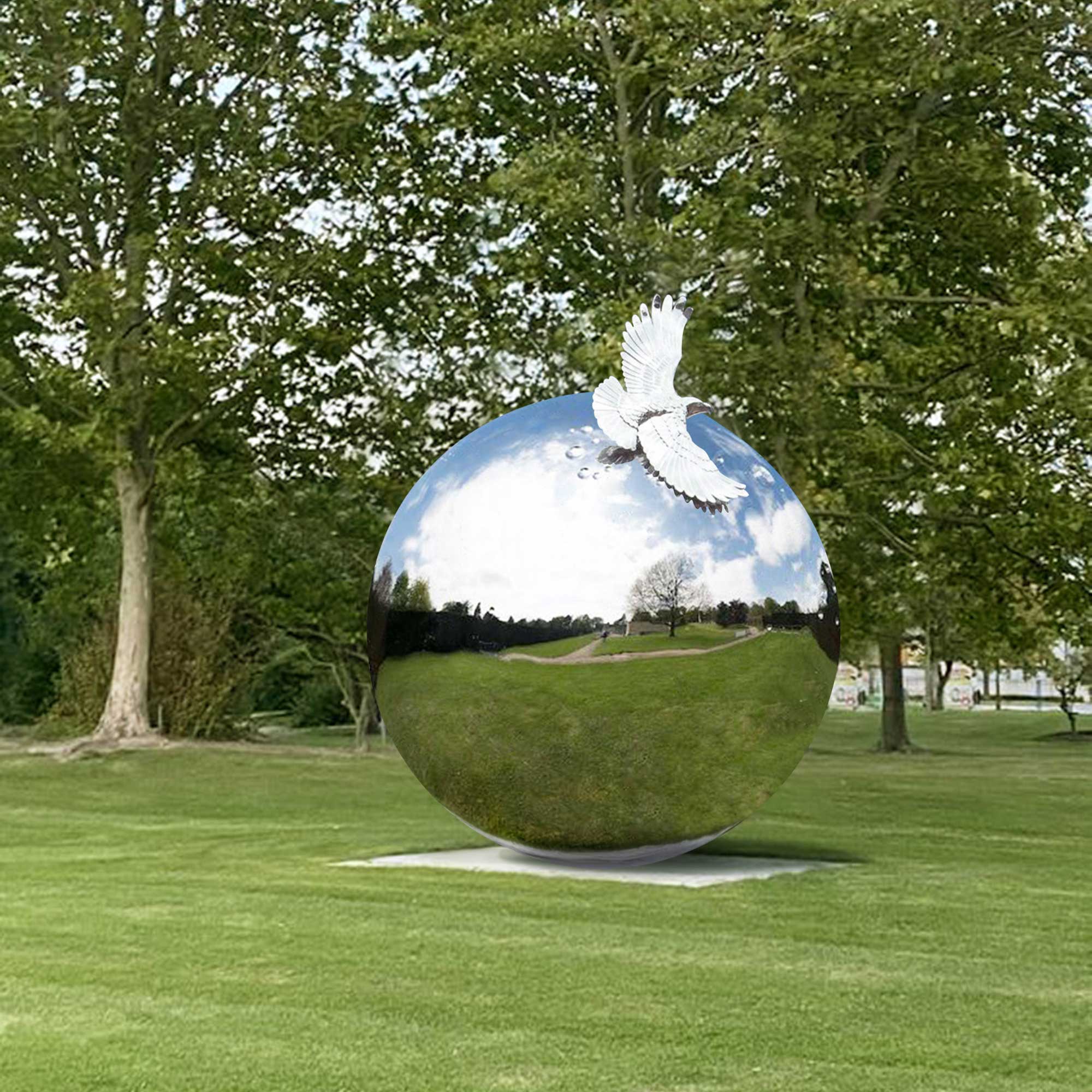 sphere stainless steel polished mirror finish sculpture with eagle on top on the lawn