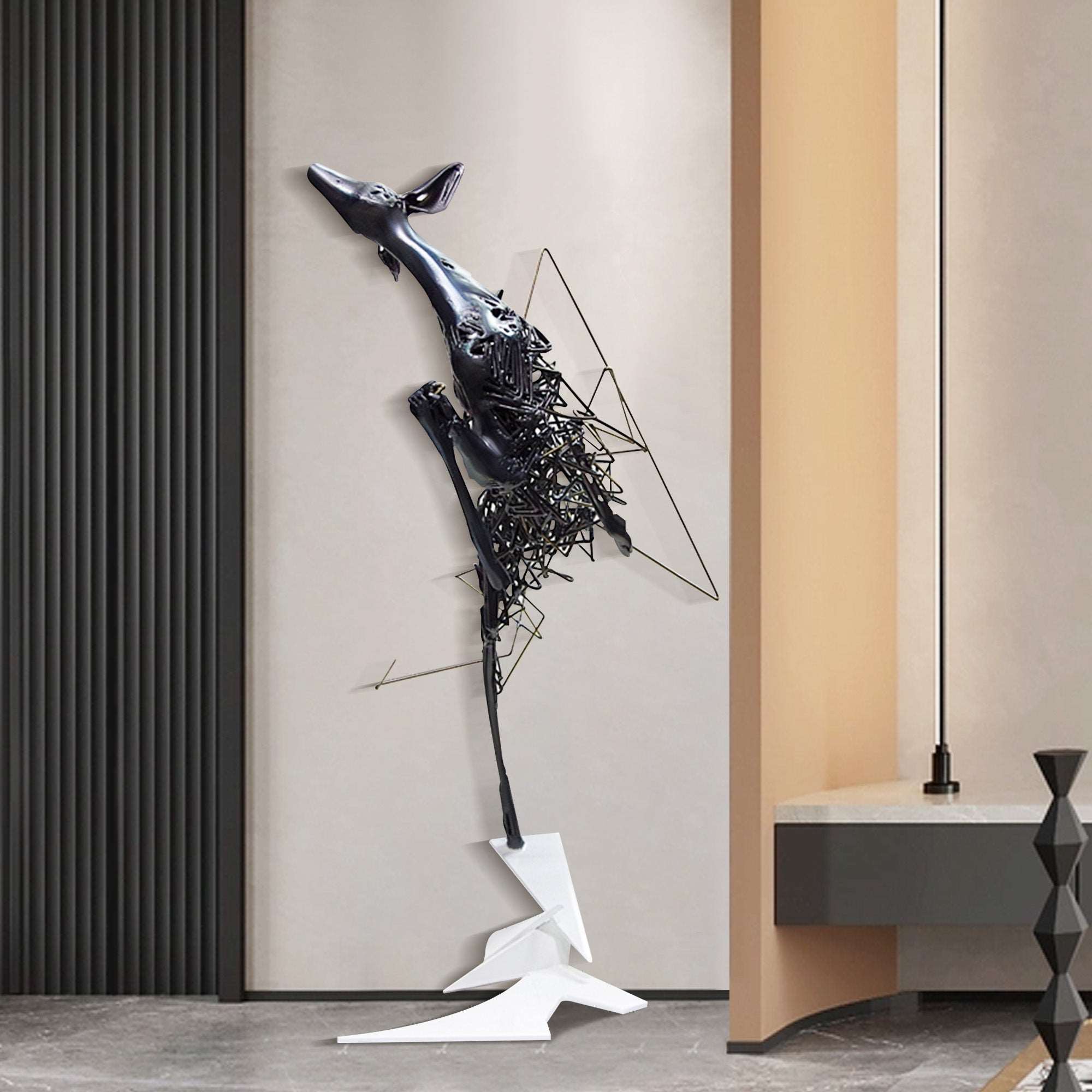 Abstract metal floor sculpture of a deer with fragmented design in glossy black and matte white, displayed in a modern interior.