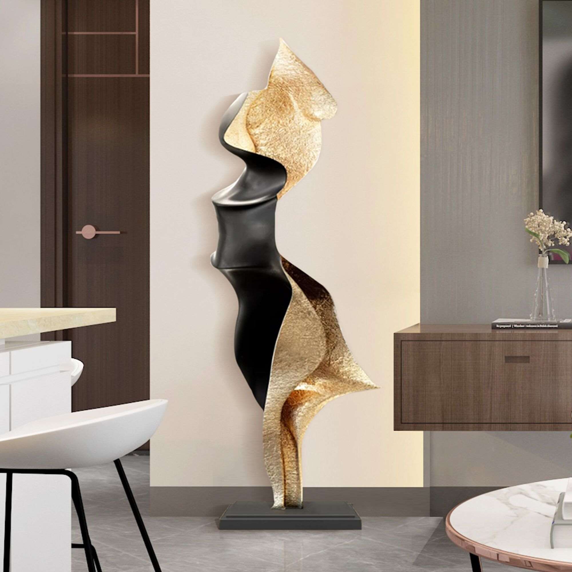 Abstract gold and black floor sculpture with flowing curves in a modern interior setting.