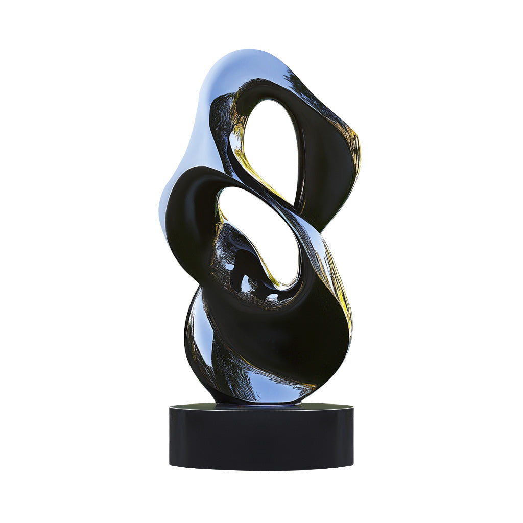 Modern abstract polished black outdoor sculpture with flowing curves, displayed on a black base in a landscaped garden setting.