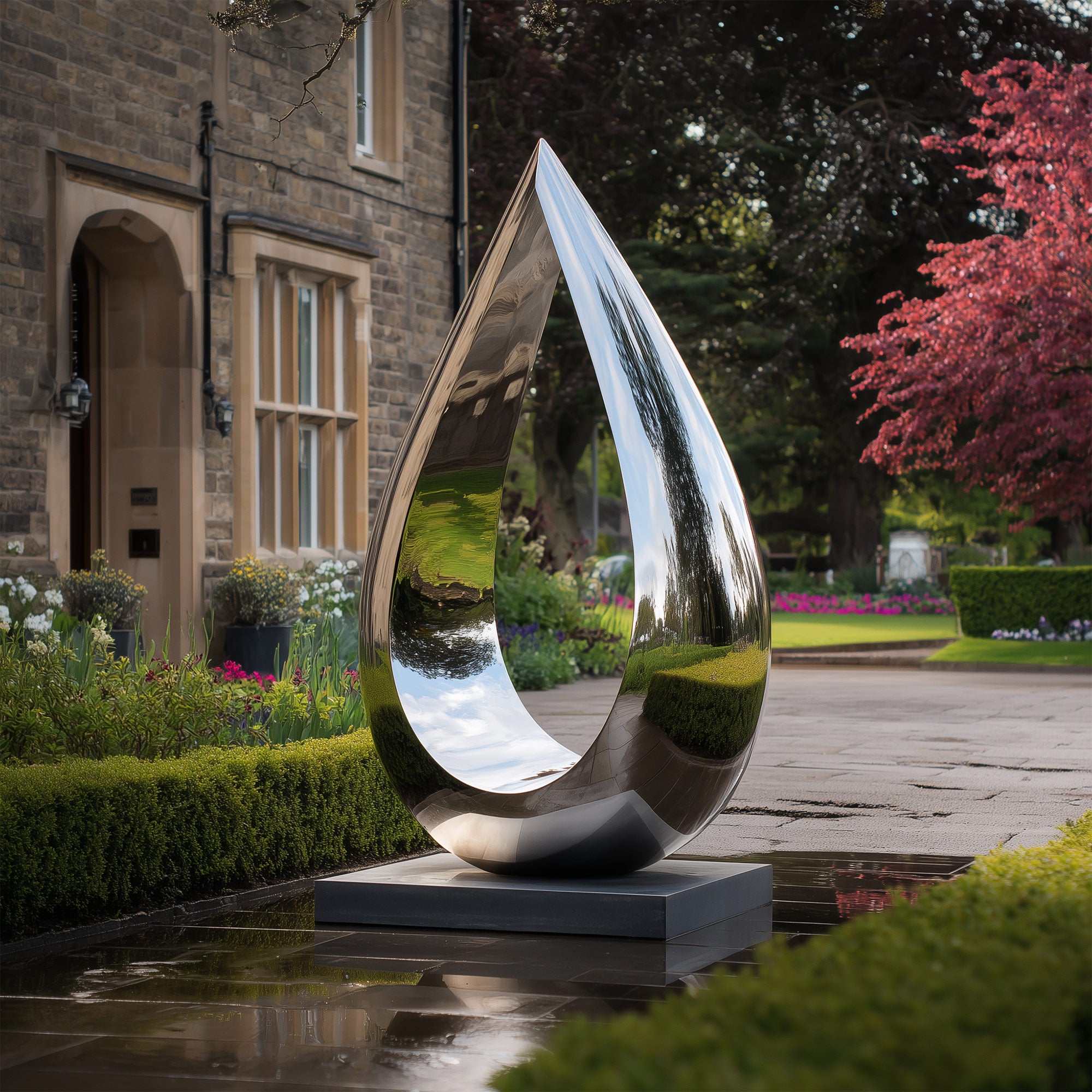 stainless steel sculpture in a garden setting with a building and trees in the background