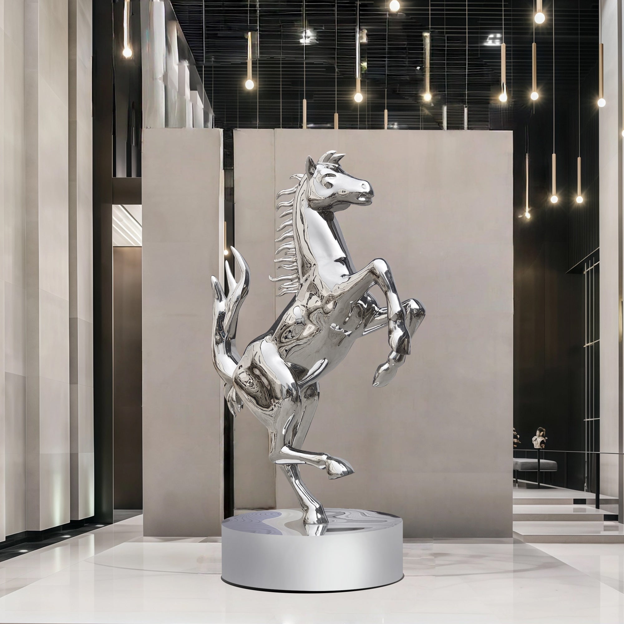 Silver stainless steel horse sculpture in a modern indoor setting with hanging lights.