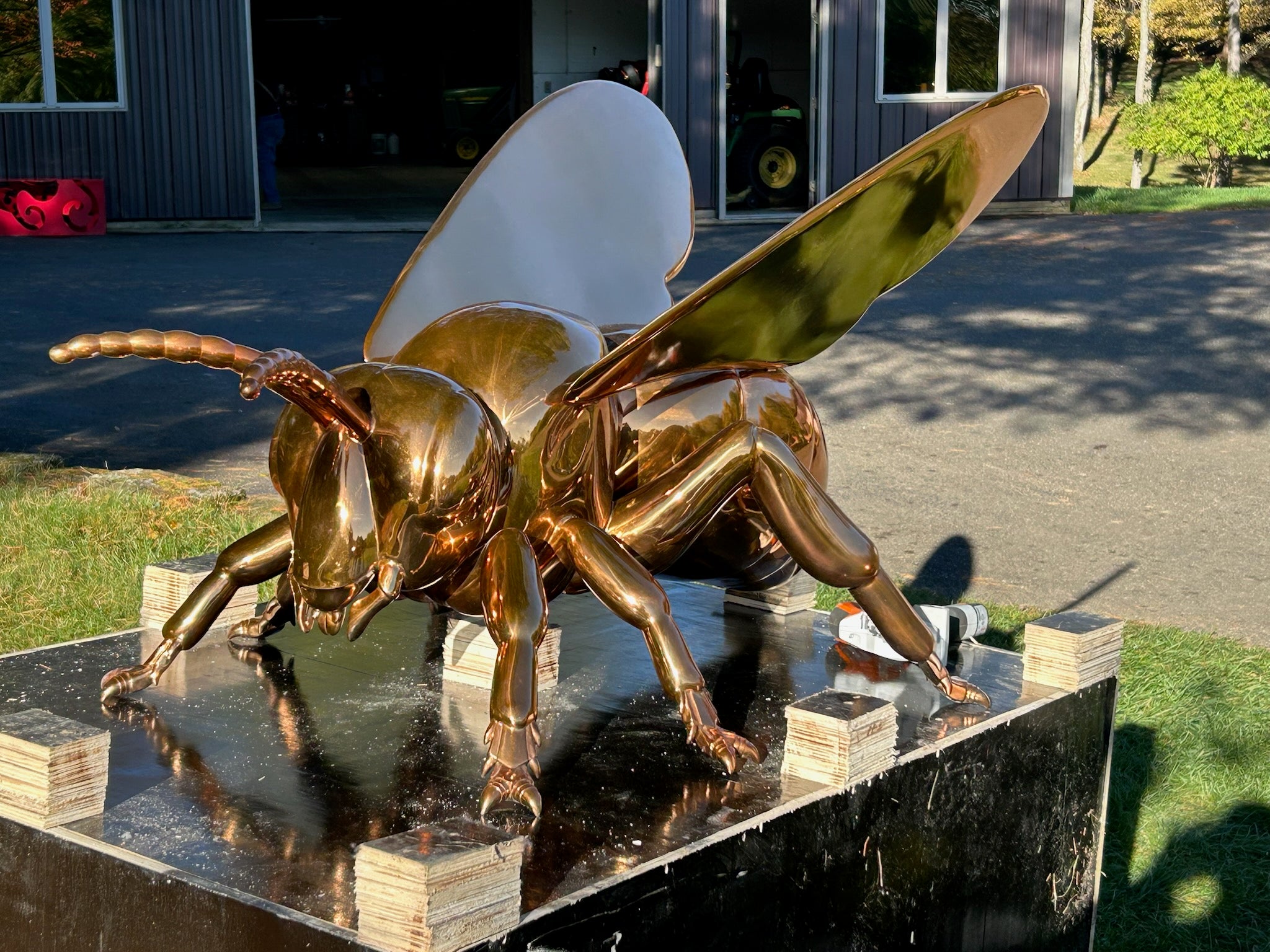 custom stainless steel bee insect sculpture with an electroplated mirror finish, designed for modern gardens and luxury outdoor spaces, showcasing detailed craftsmanship and a reflective surface under natural light