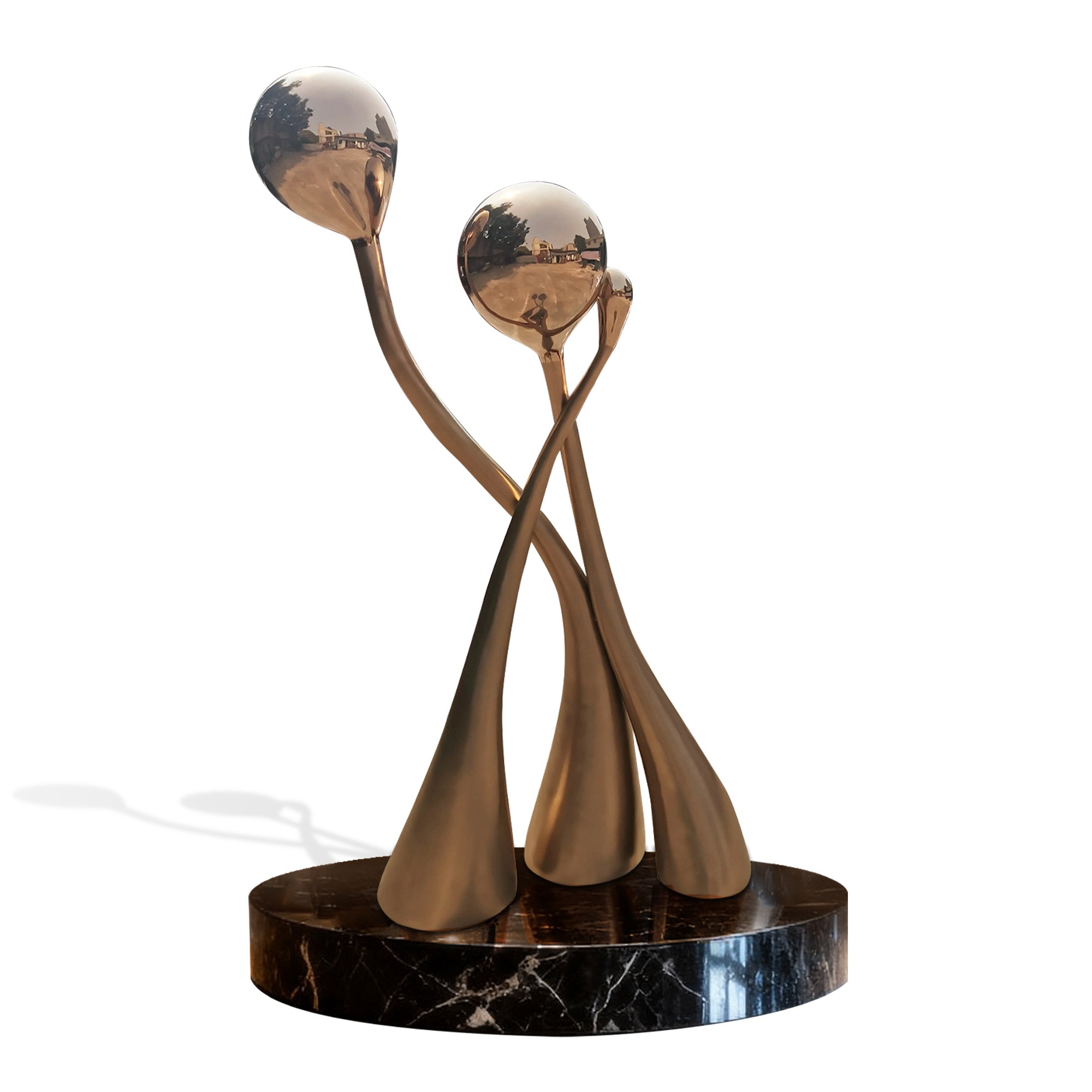 Decorative stainless steel sculpture on a black marble base against a white background