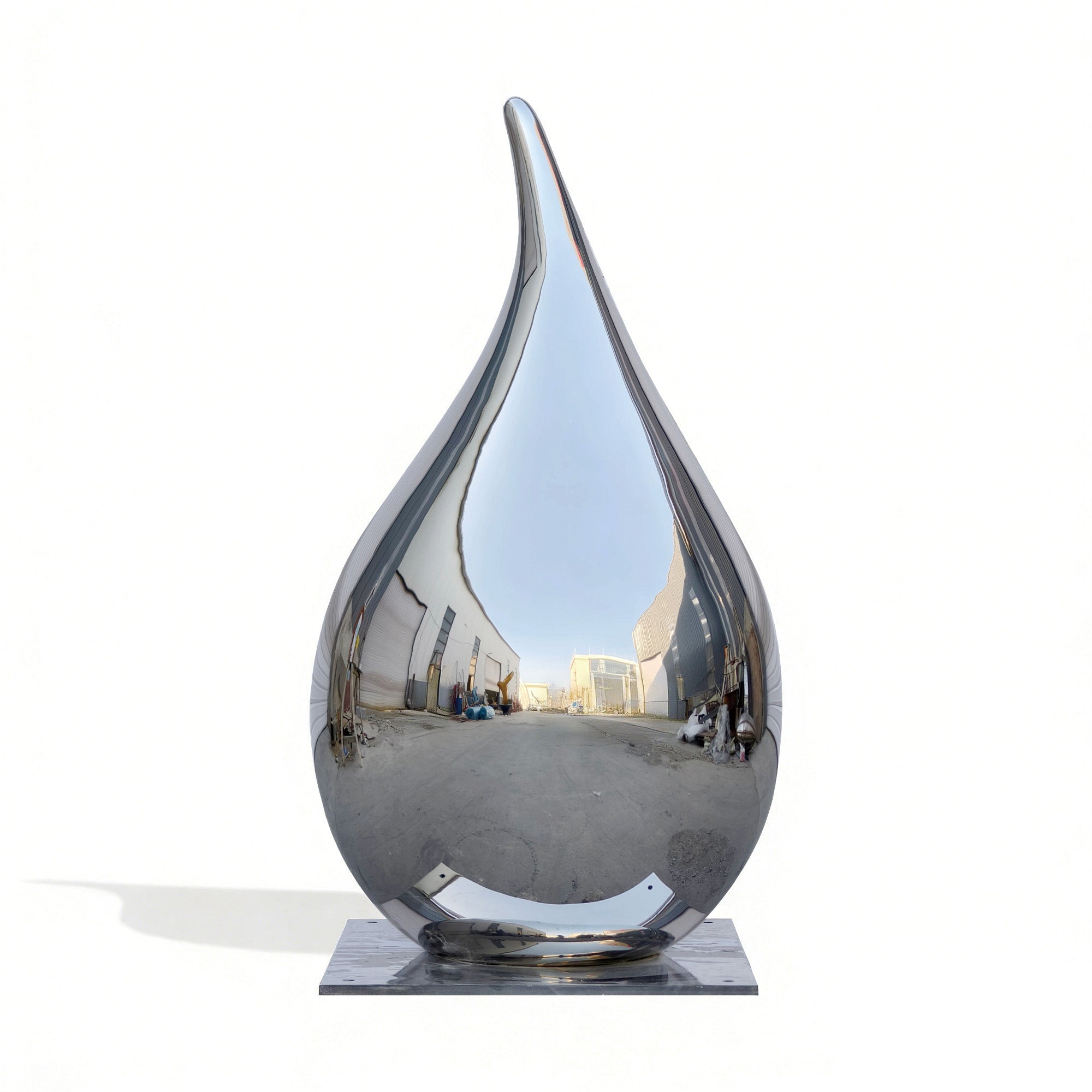 A large stainless steel drop sculpture reflecting its surrounding environment, showcasing its sleek, modern design.