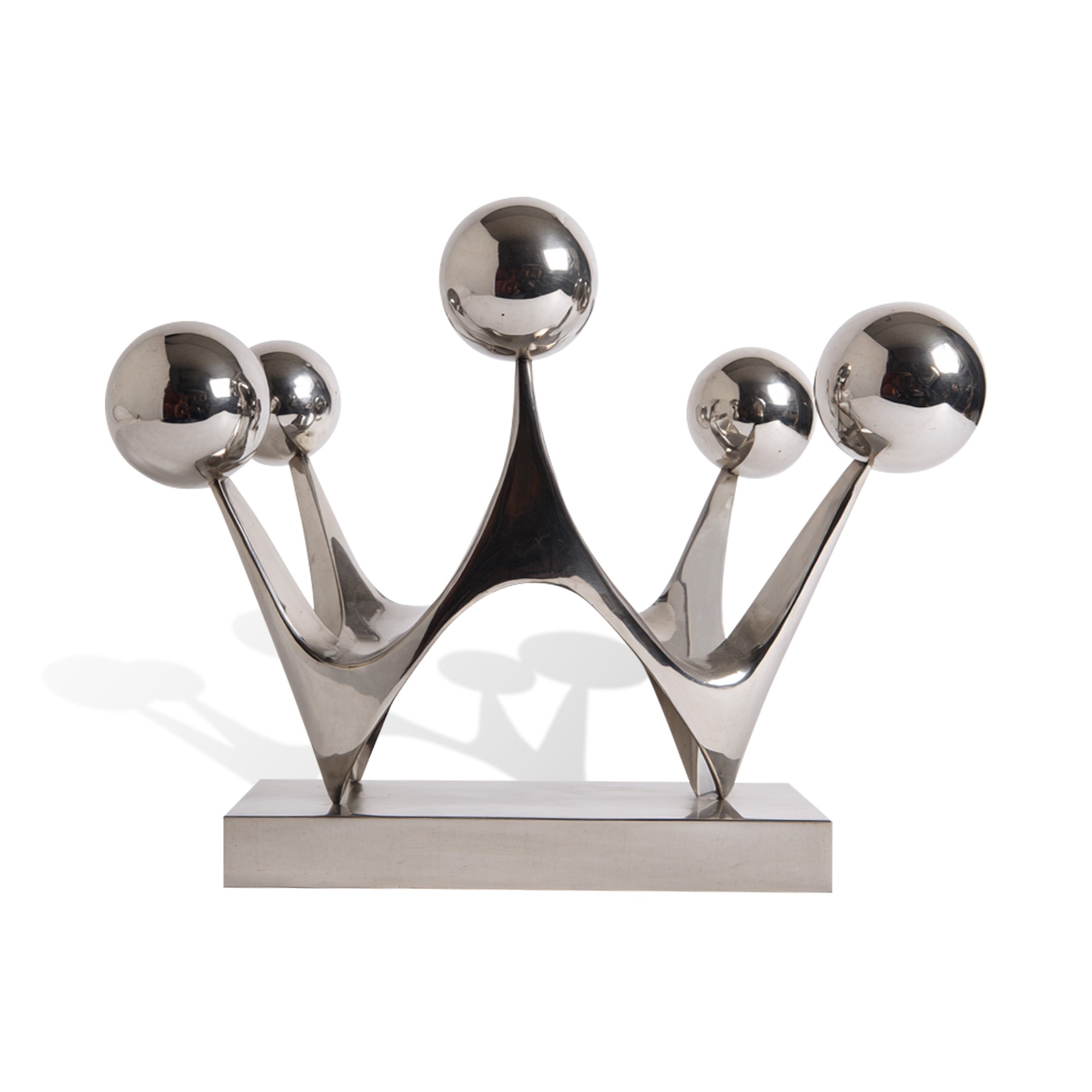 A polished stainless steel crown-inspired sculpture placed in a luxurious interior. The reflective surface contrasts beautifully with the modern architecture, adding sophistication and elegance to the space.