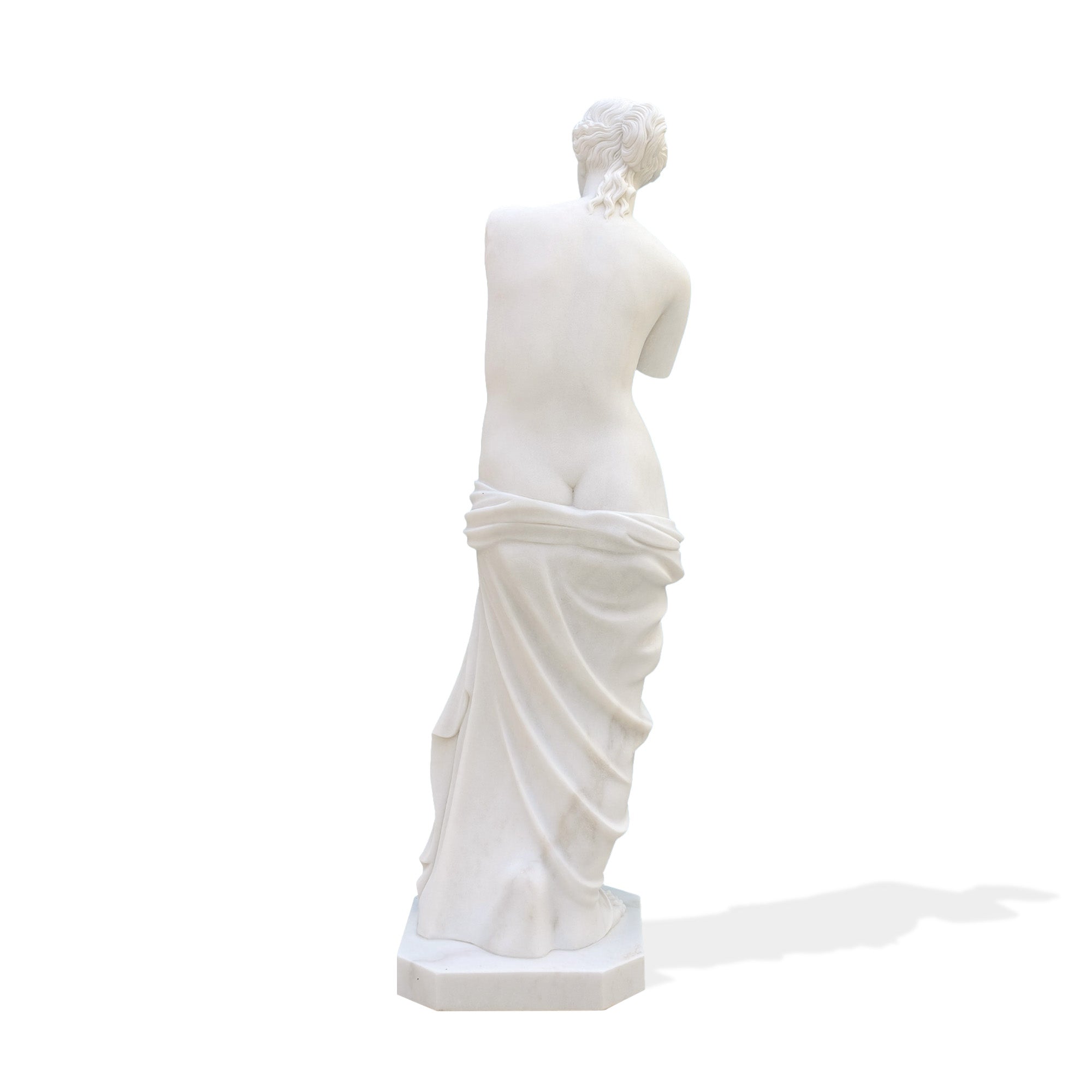 Back view of marble Venus de Milo statue replica, classical female figure sculpture showing detailed back and draped garment on pedestal base.