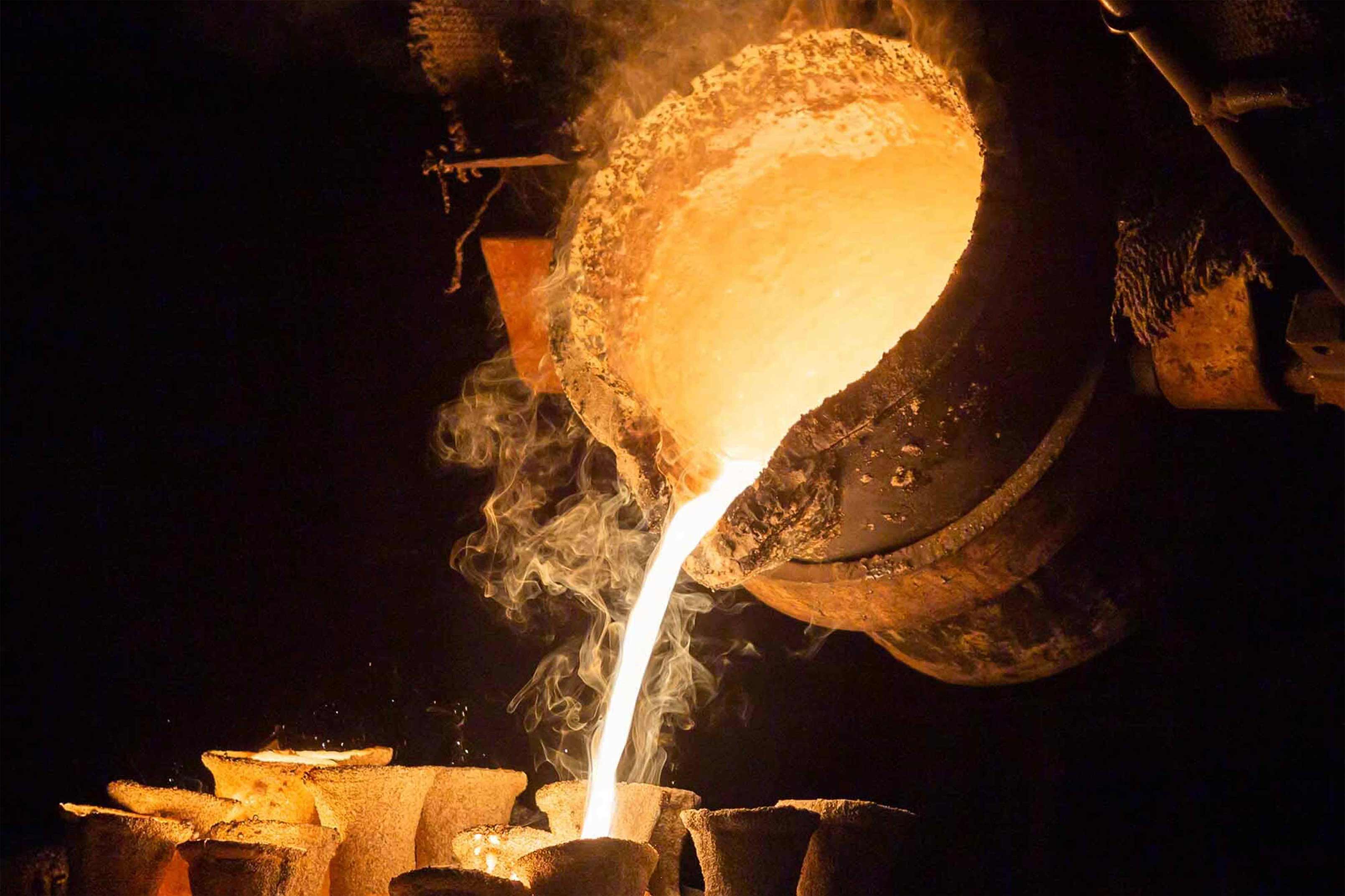 pouring Molten bronze into the mold 